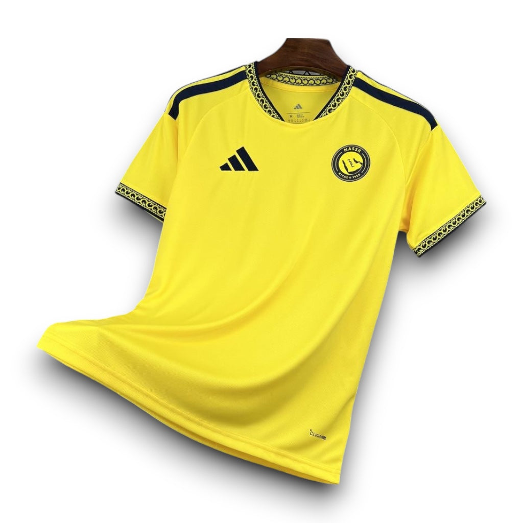 Leazofoot Al-Nassr 26/27 home jersey in bright yellow with black accents, patterned collar, and team crest.