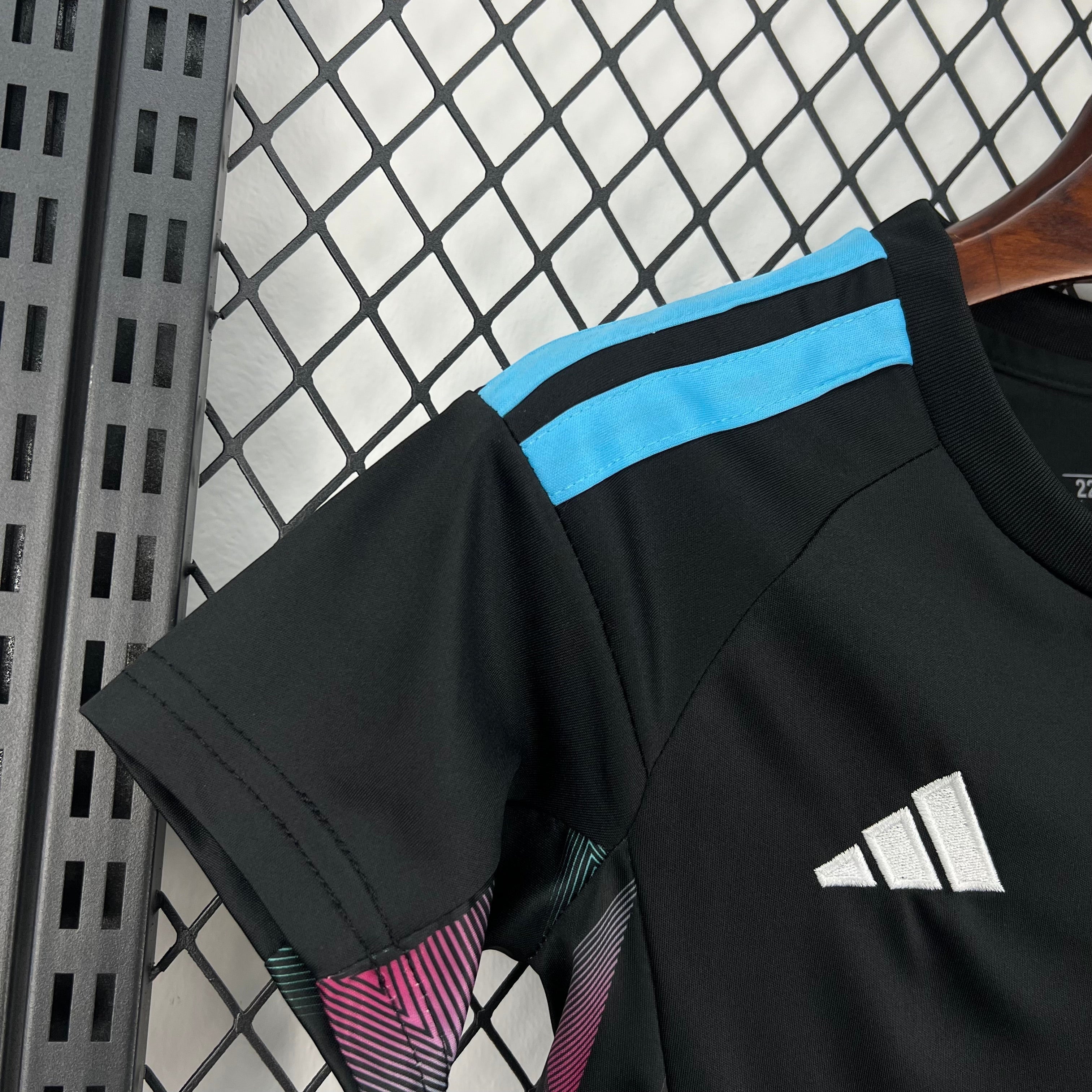 Leazofoot black short-sleeve soccer jersey with light blue stripes on shoulders and colorful geometric pattern on sleeve hem.