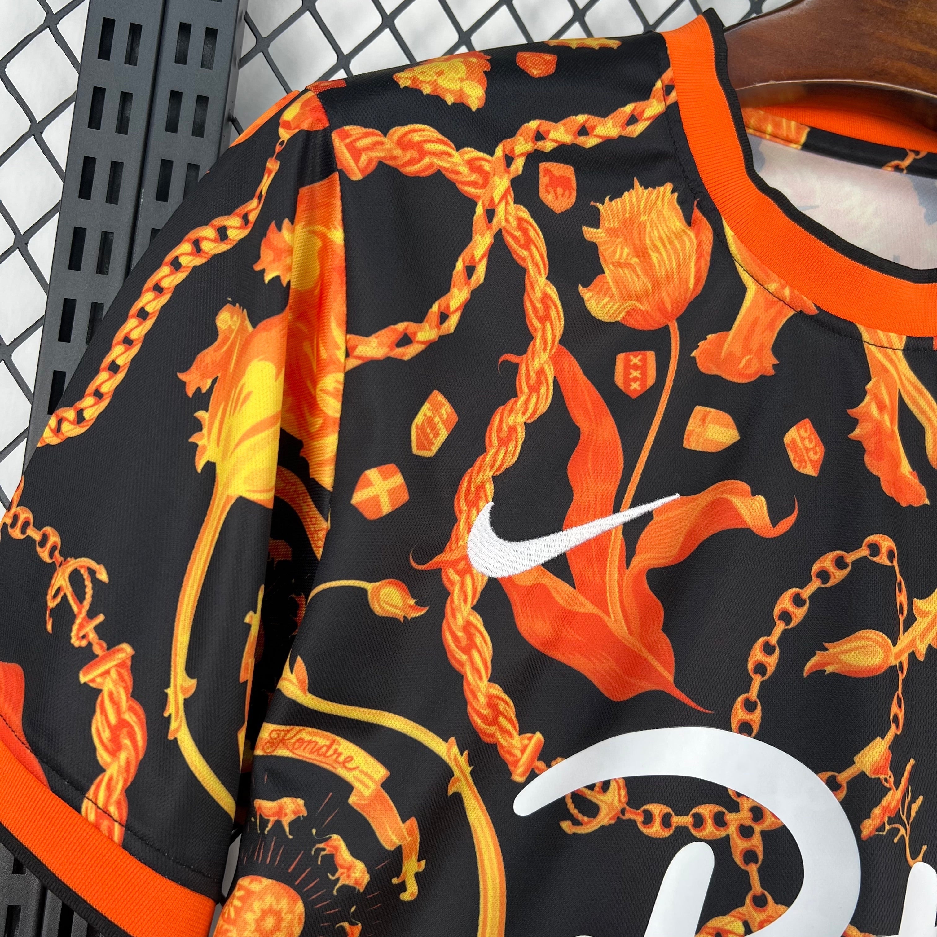 Leazofoot black short-sleeve soccer jersey with orange floral and chain print, featuring a white Nike logo.