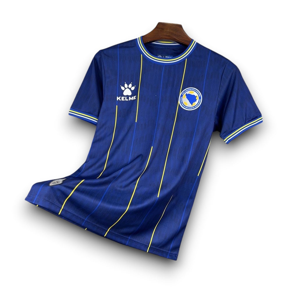 Leazofoot BOSNIE 2026 home jersey: blue with vertical yellow pinstripes, white and yellow trim on collar and sleeves.