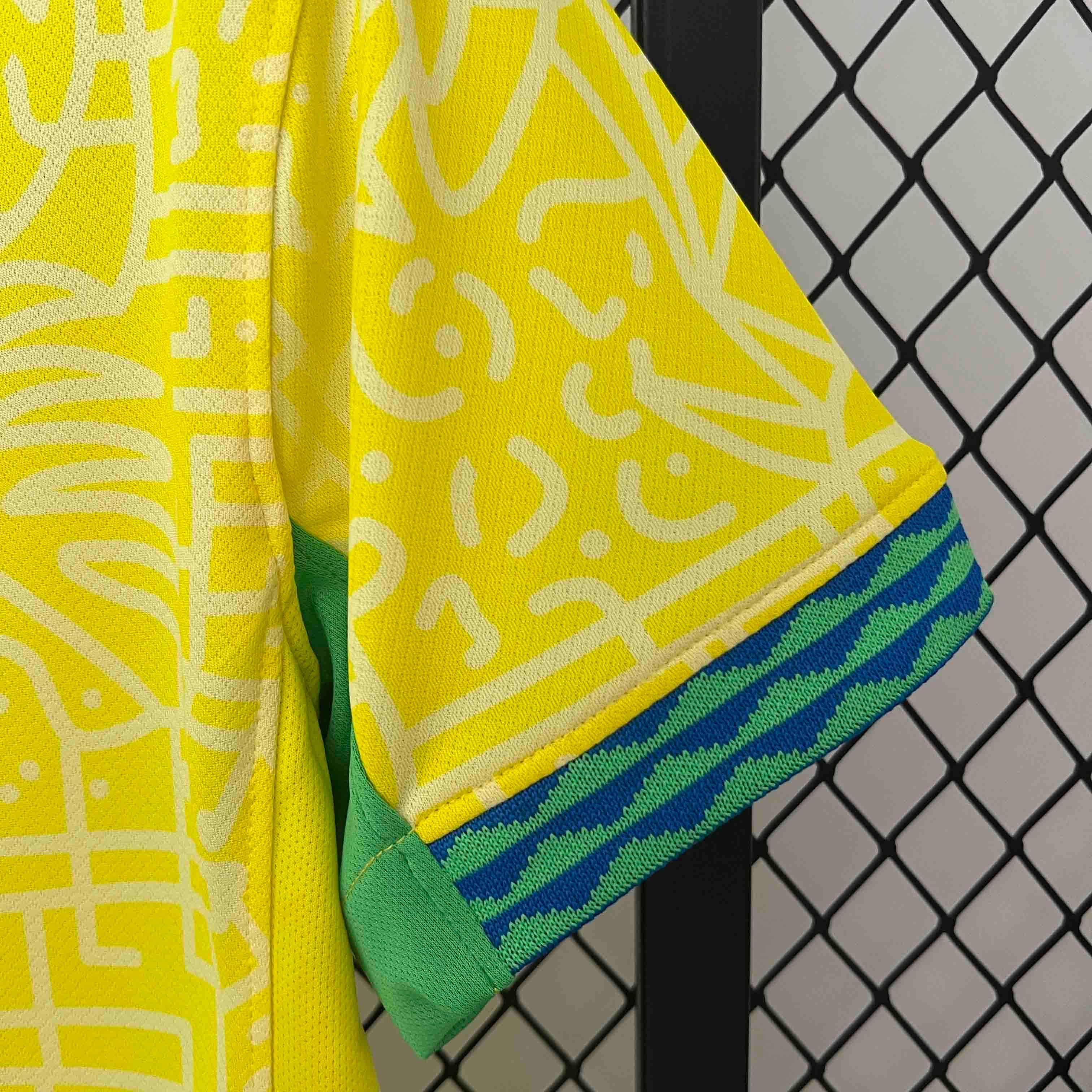 Leazofoot Brazil 2024 home soccer jersey sleeve with yellow patterned fabric and green and blue striped trim.