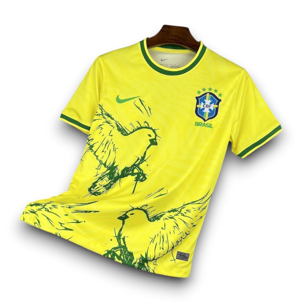 Leazofoot Brazil 23/24 yellow soccer jersey with green bird graphic print and CBF crest on a black grid background.