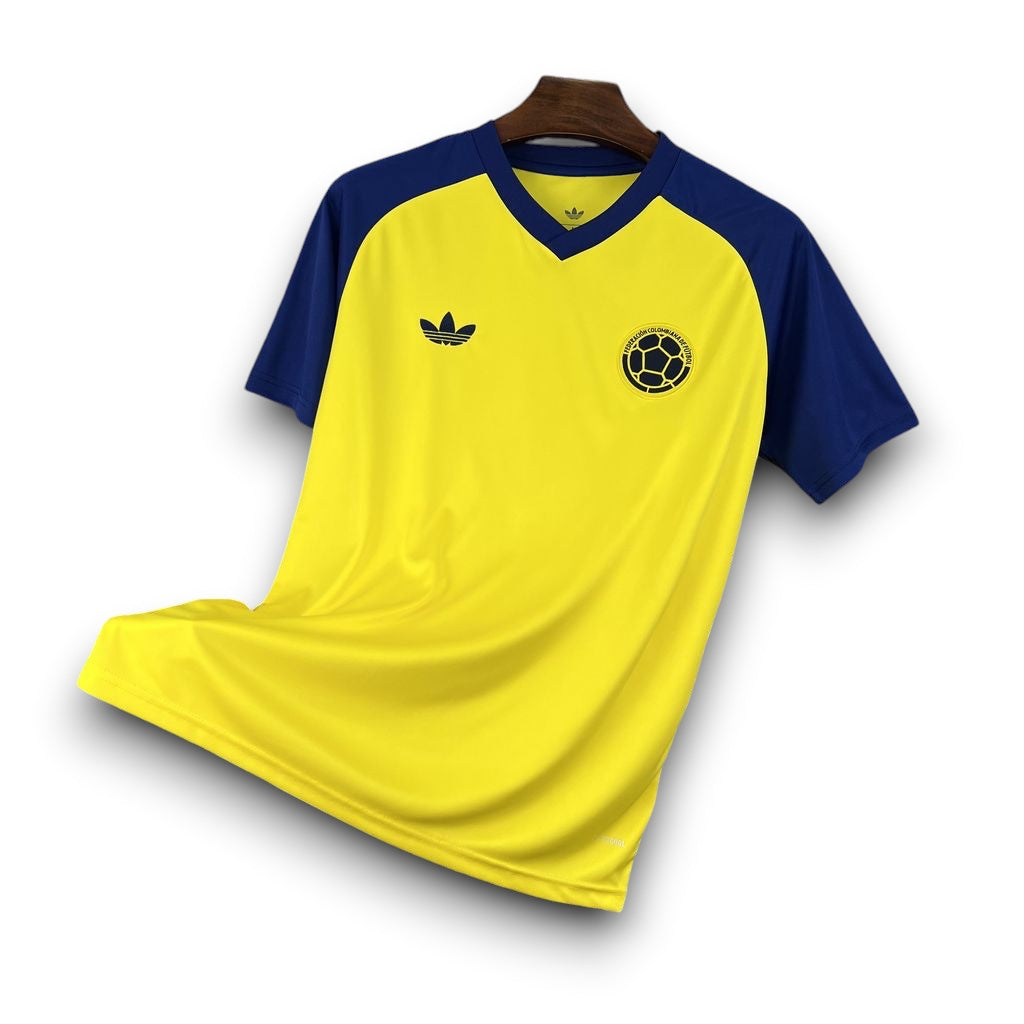 Leazofoot Colombia 2026 pre-match soccer jersey in yellow with blue sleeves, V-neck, and team crest.