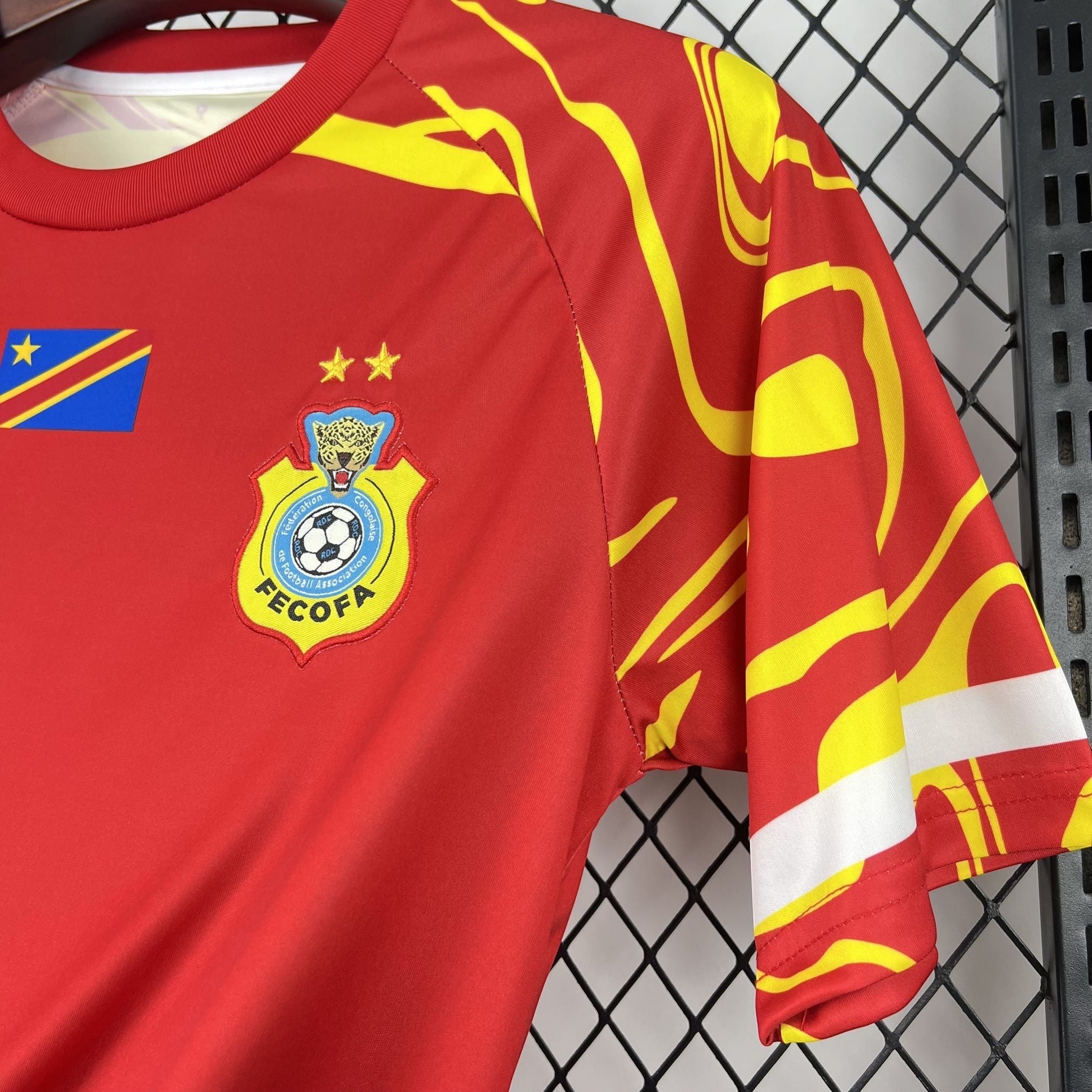 Leazofoot CONGO - MAILLOT EXTÉRIEUR THIRD 2026 red soccer jersey with yellow abstract pattern on sleeves and team crest.