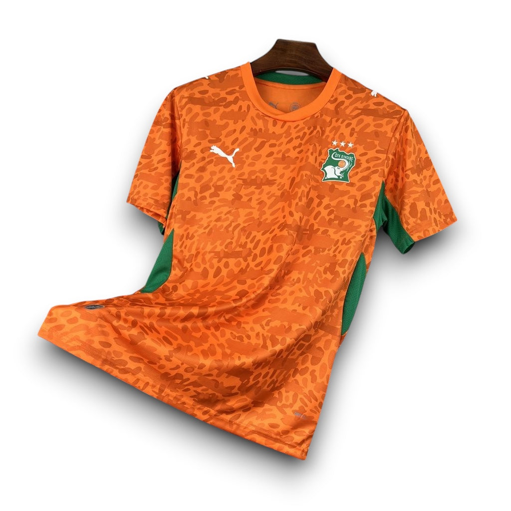 Leazofoot Côte d'Ivoire 2026 home football jersey in orange with a leopard print pattern and green side panels.