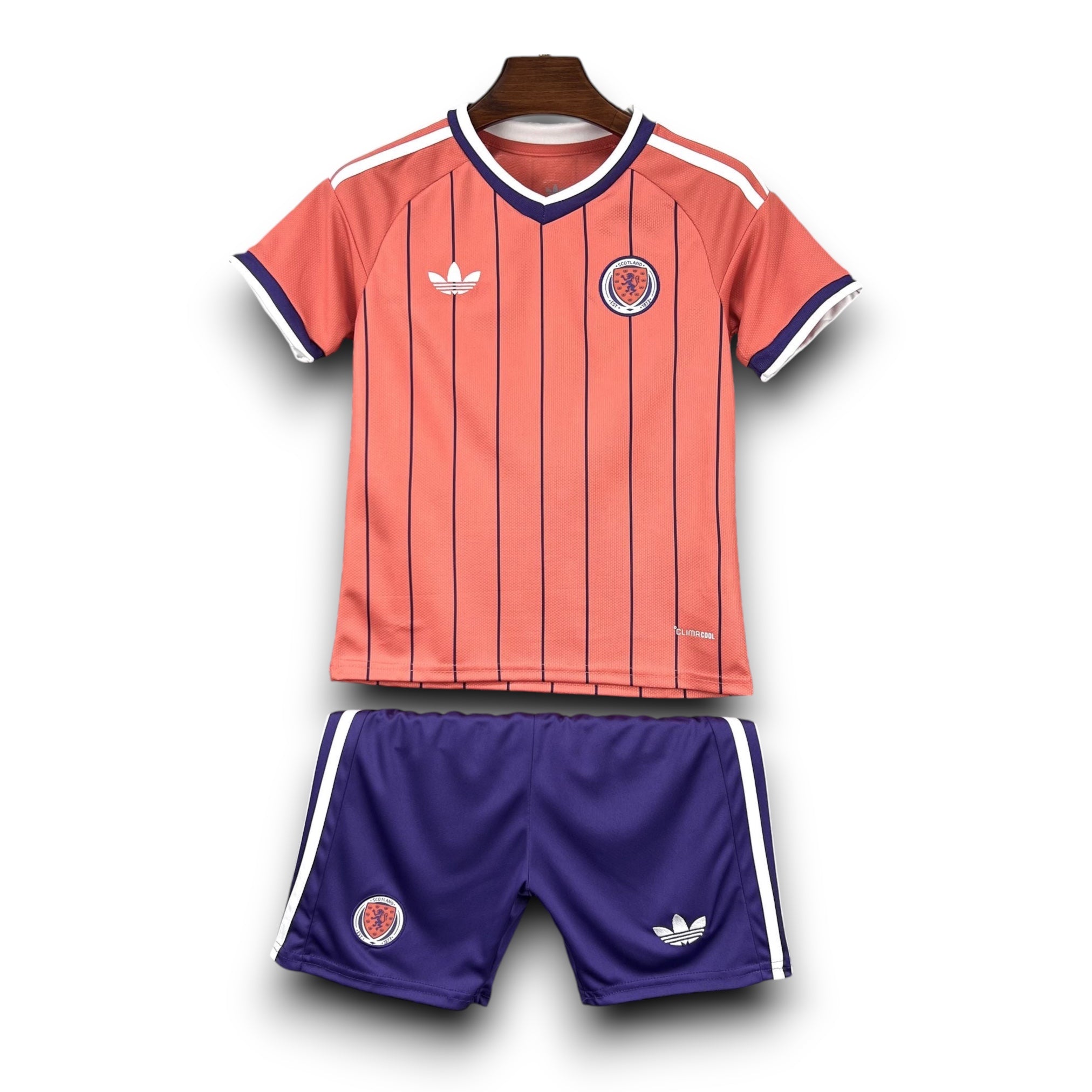 Leazofoot ÉCOSSE children's football kit: coral jersey with vertical navy stripes and purple trim, navy shorts with white stripes.
