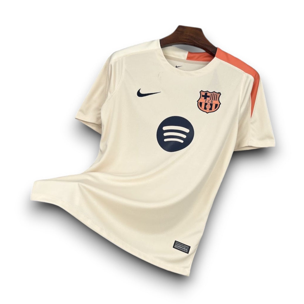 Leazofoot FC Barcelona 24/25 training jersey in cream with orange shoulder detail and black sponsor logo