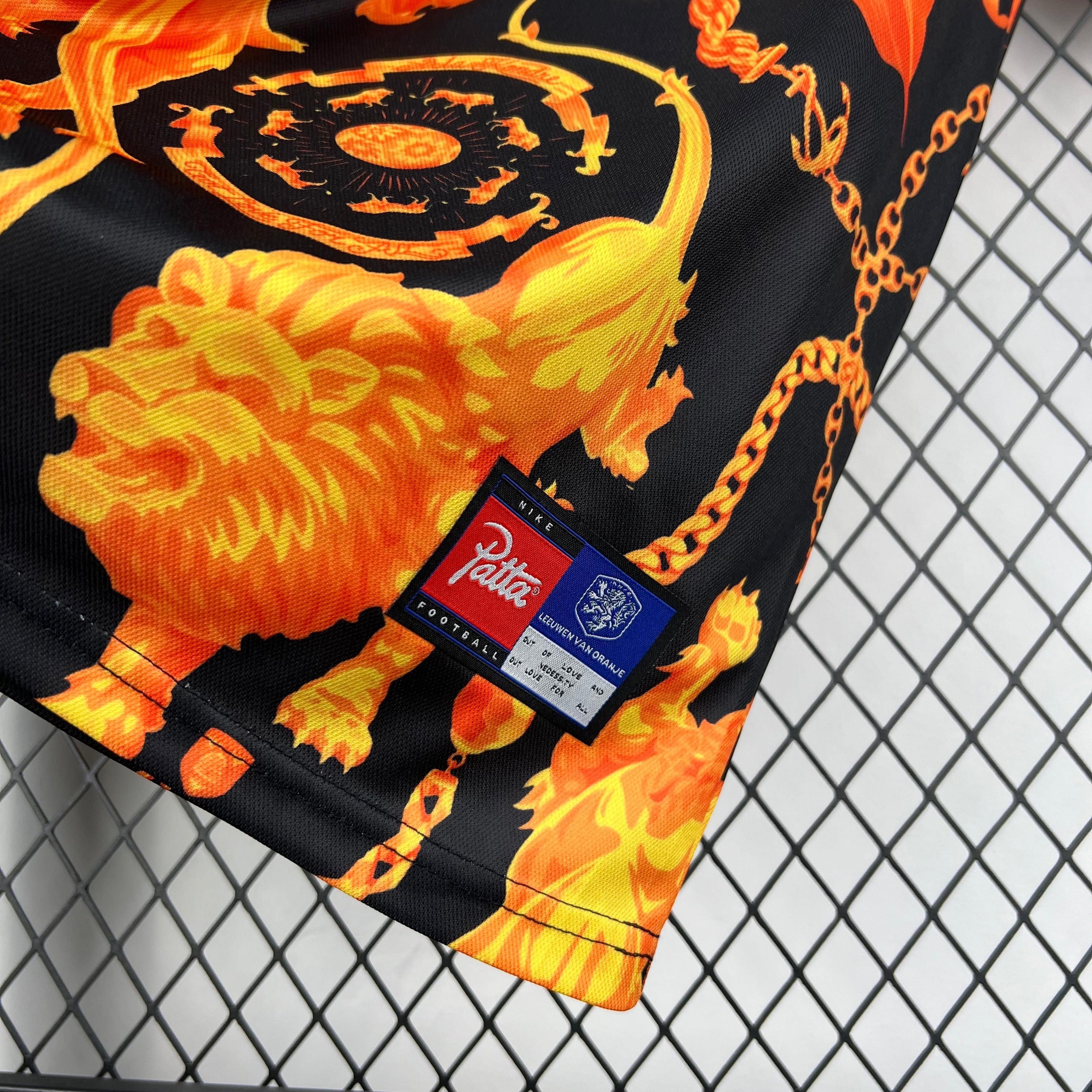 Leazofoot black football shorts with orange lion and chain print, featuring a Patta and Nike logo tag.