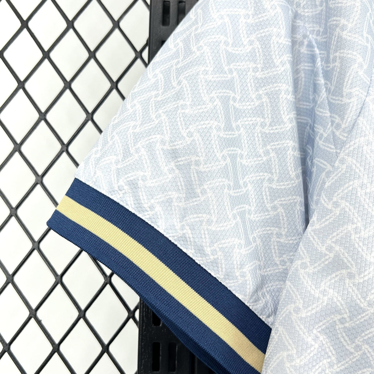 Leazofoot Italy 2026 away jersey sleeve featuring a light blue geometric pattern with navy and yellow ribbed cuffs.