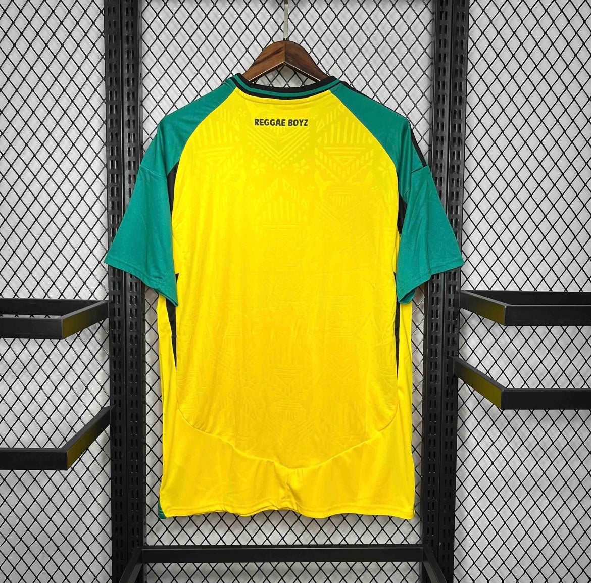 Leazofoot Jamaica 2024 home jersey in yellow and green with Reggae Boyz text on the back, hanging on a display rack.