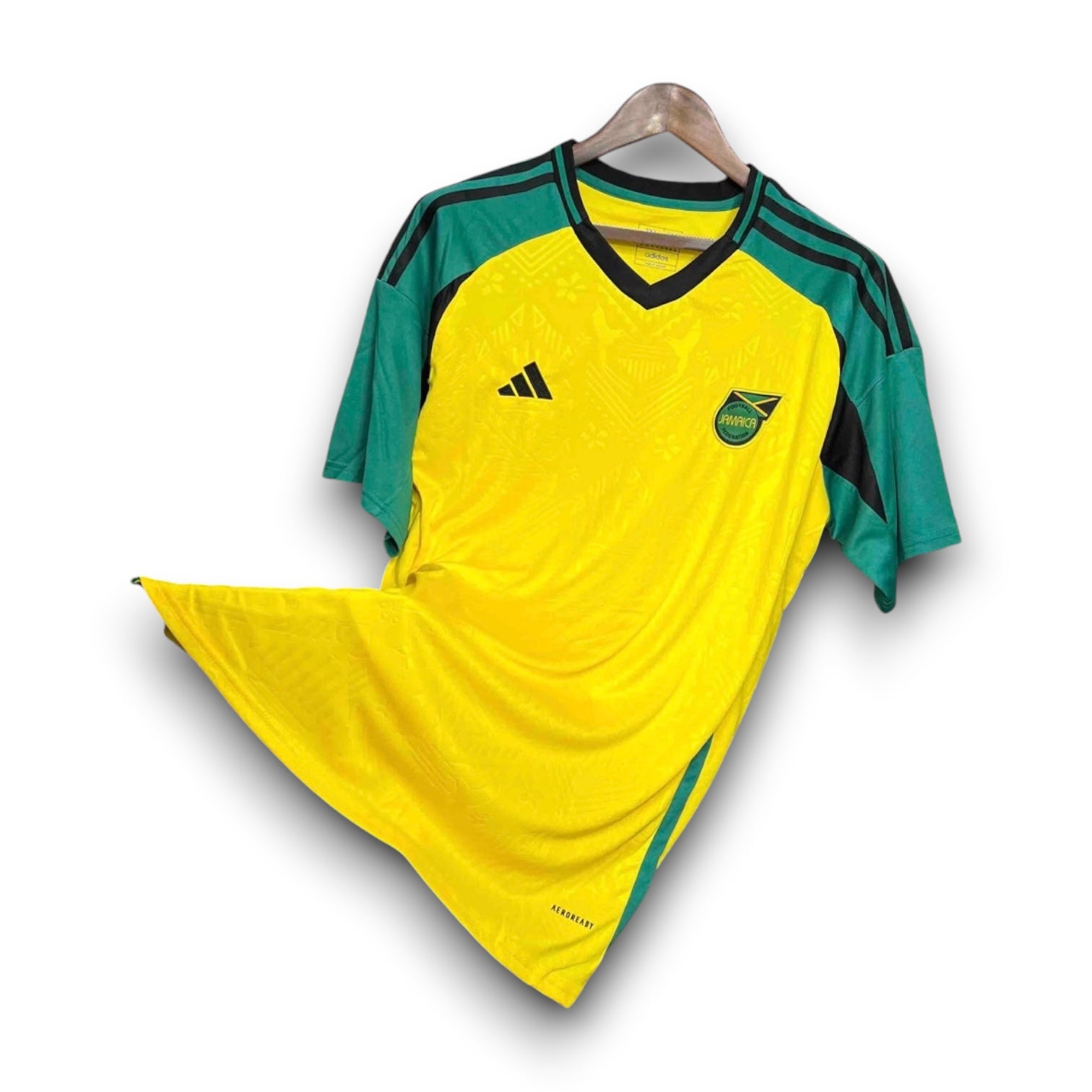 Leazofoot Jamaica 2024 home football jersey in yellow with green sleeves and black Adidas detailing.