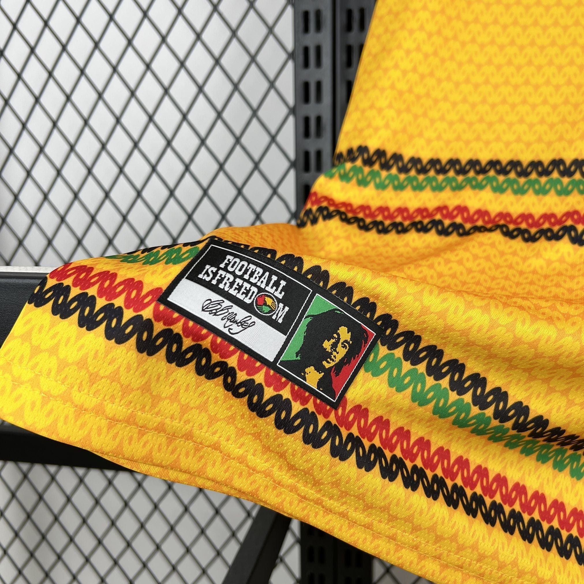 Leazofoot Jamaica 2026 home soccer jersey in yellow with green, red, and black stripes and Bob Marley patch detail.