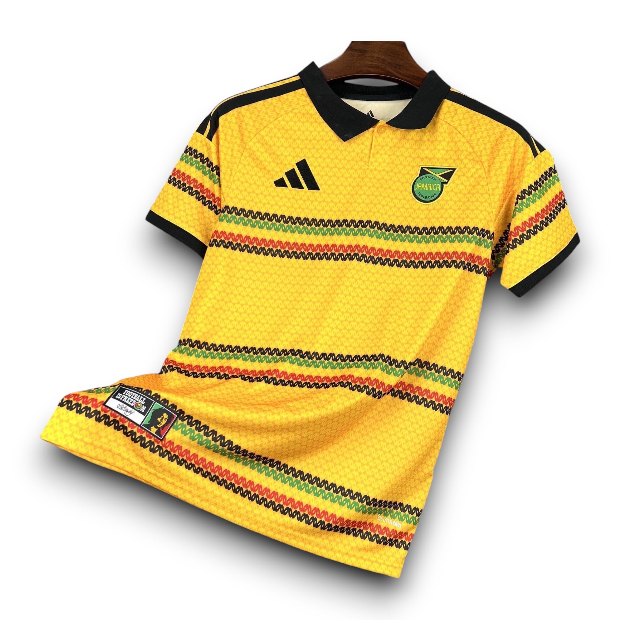 Leazofoot Jamaica 2026 home football jersey in yellow with black collar and red, green, and black patterned stripes.
