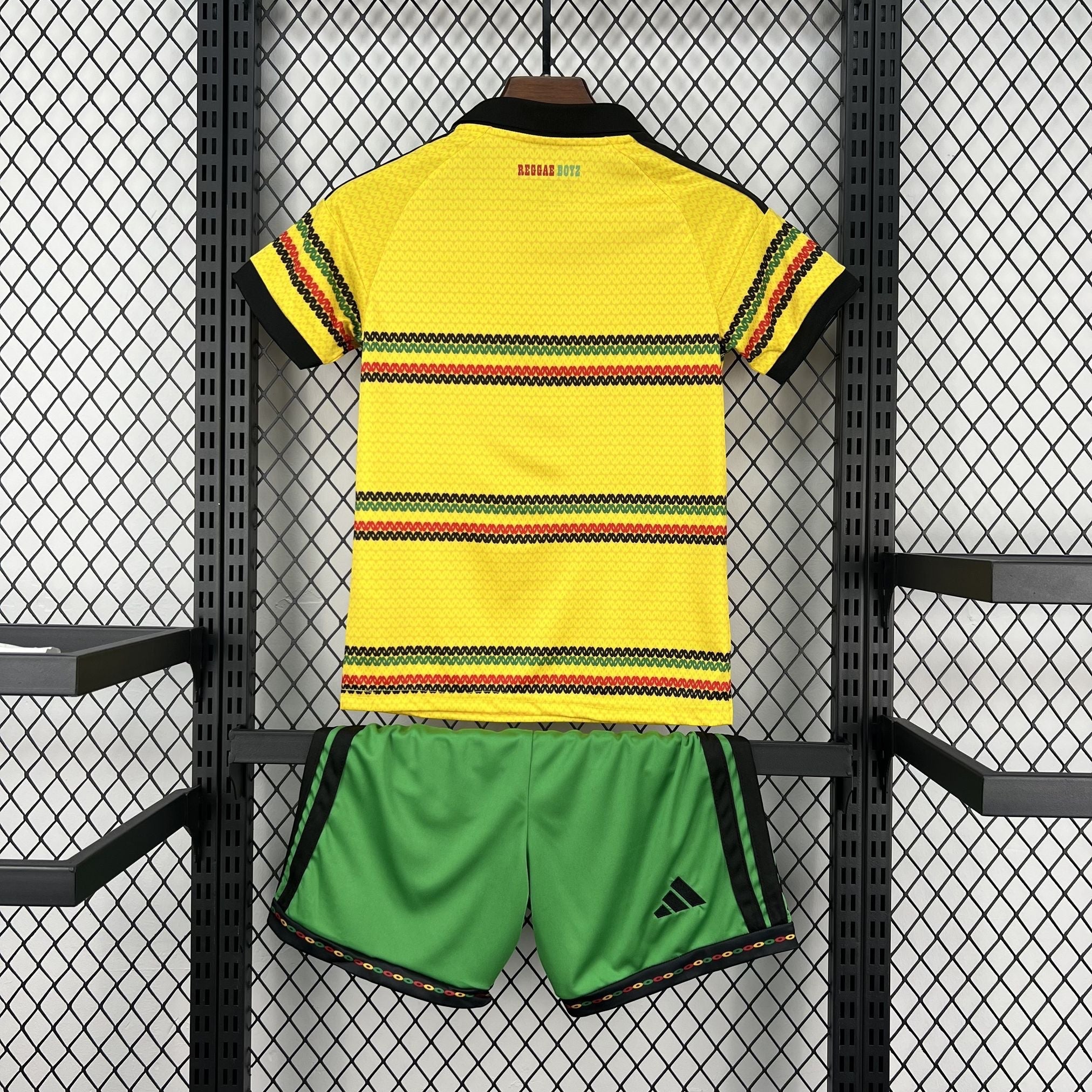 Leazofoot Jamaica 2026 kids home kit featuring a yellow jersey with rasta-colored stripes and green soccer shorts.