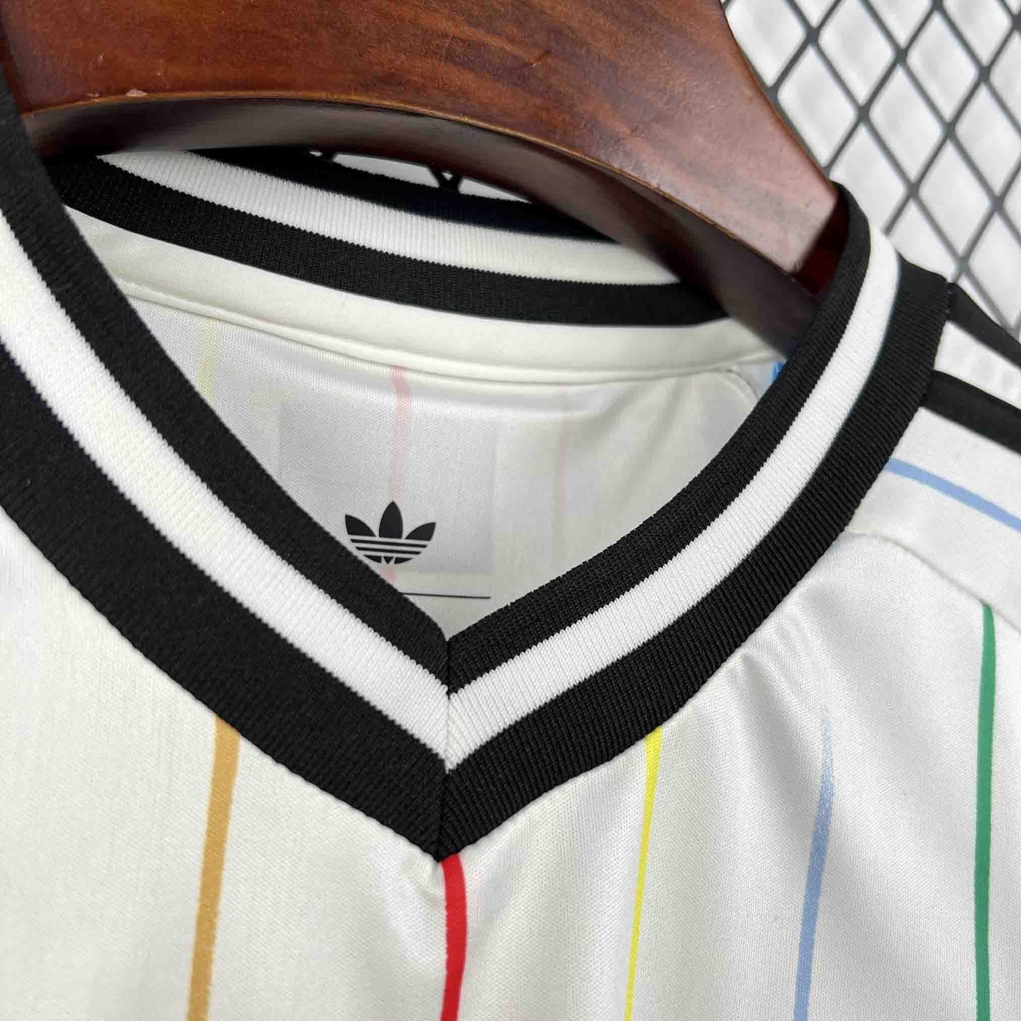 Leazofoot JAPON 2026 away jersey with a white base and multi-colored vertical stripes. Features a black and white striped V-neck.