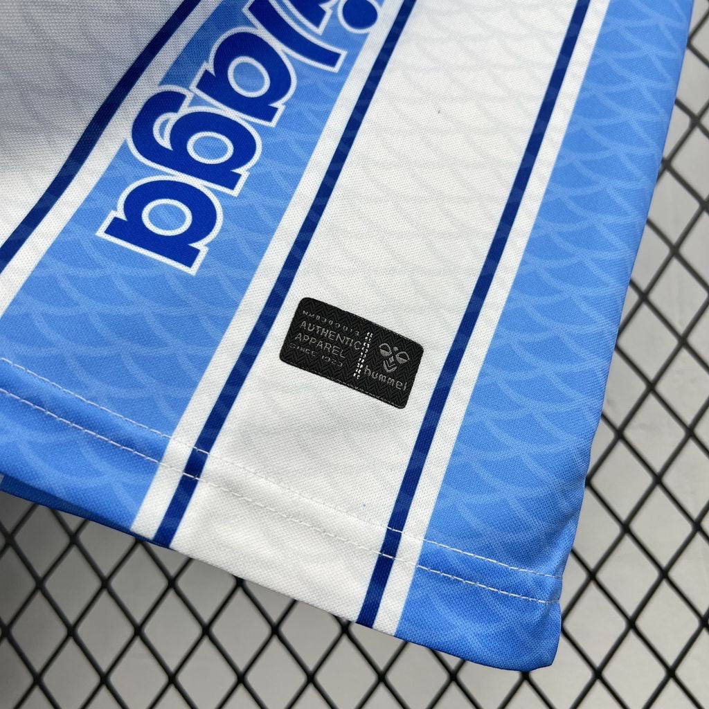 Leazofoot Malaga 26/27 home football jersey in white and blue with Hummel authentic apparel patch detail.