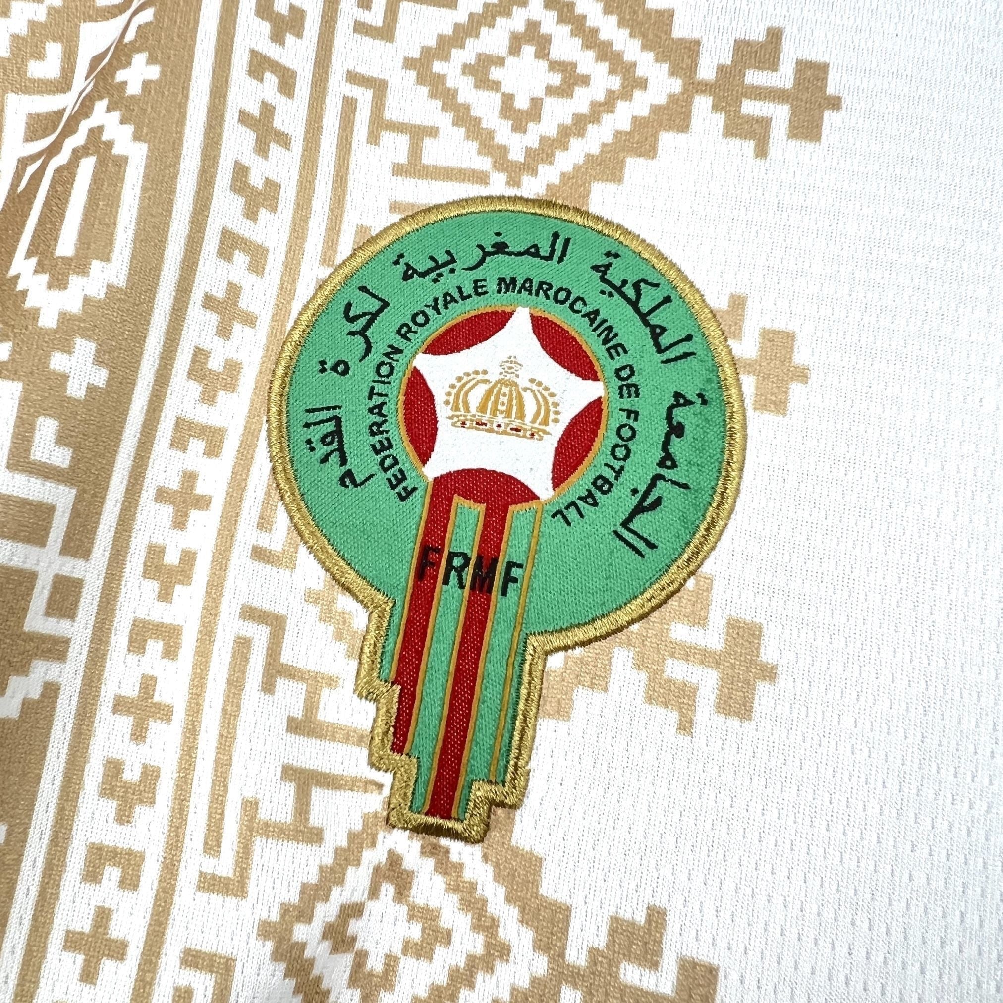 Leazofoot MAROC 2026 away football jersey, white with gold geometric pattern and embroidered team crest.