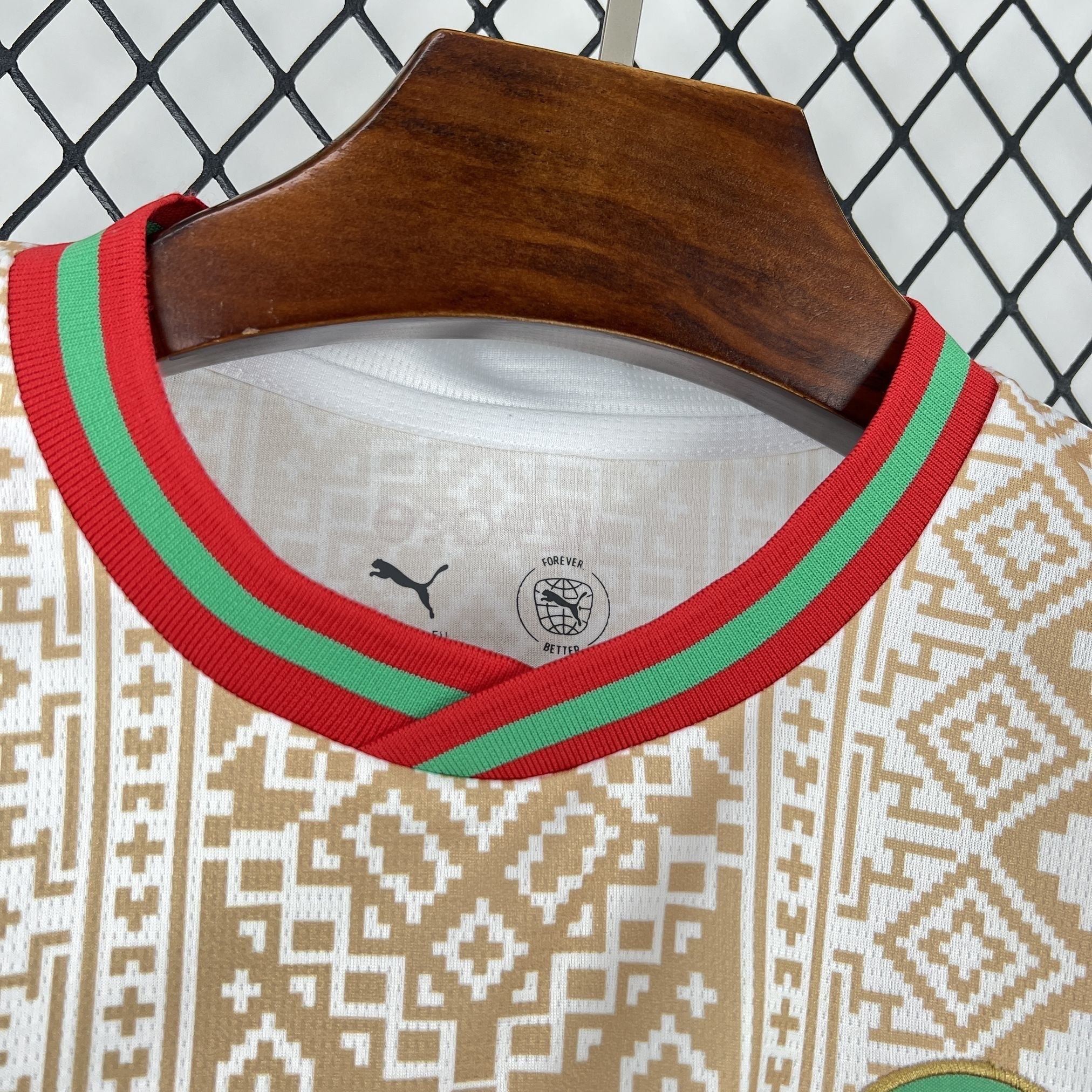 Leazofoot MAROC 2026 away football jersey. White with intricate gold geometric pattern, red and green collar trim.