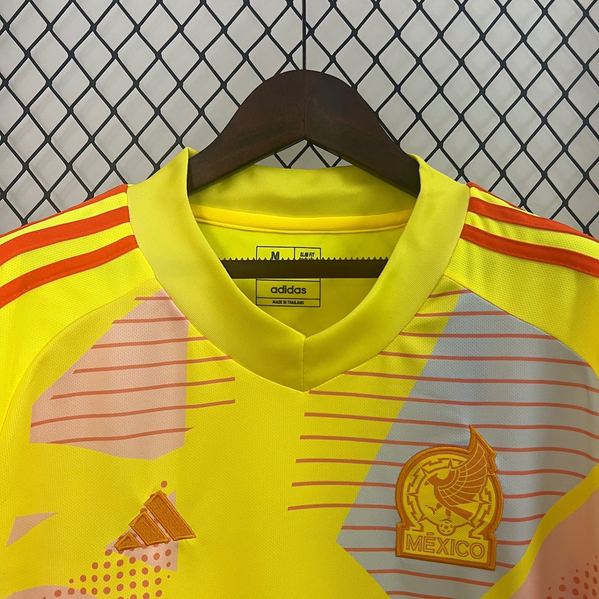 Leazofoot Mexico 2024 goalkeeper jersey in bright yellow with orange accents, graphic patterns, and team crest.