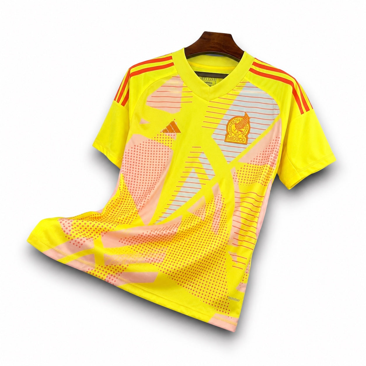 Leazofoot Mexico 2024 goalkeeper jersey in bright yellow with orange graphic patterns and team crest on hanger