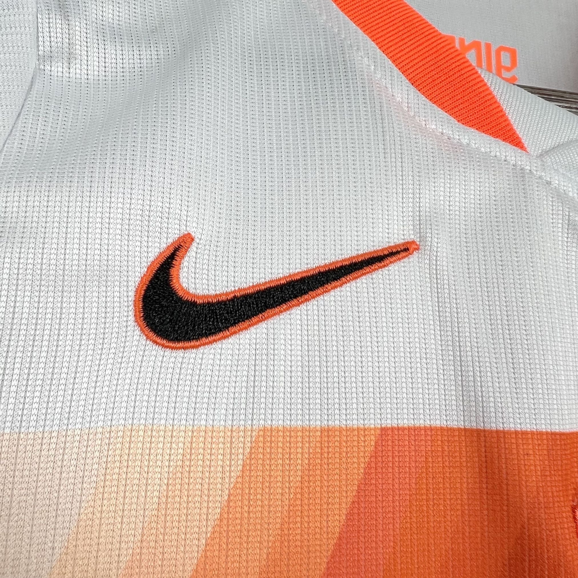 Leazofoot white and orange Nike soccer jersey with black swoosh logo and gradient detail.
