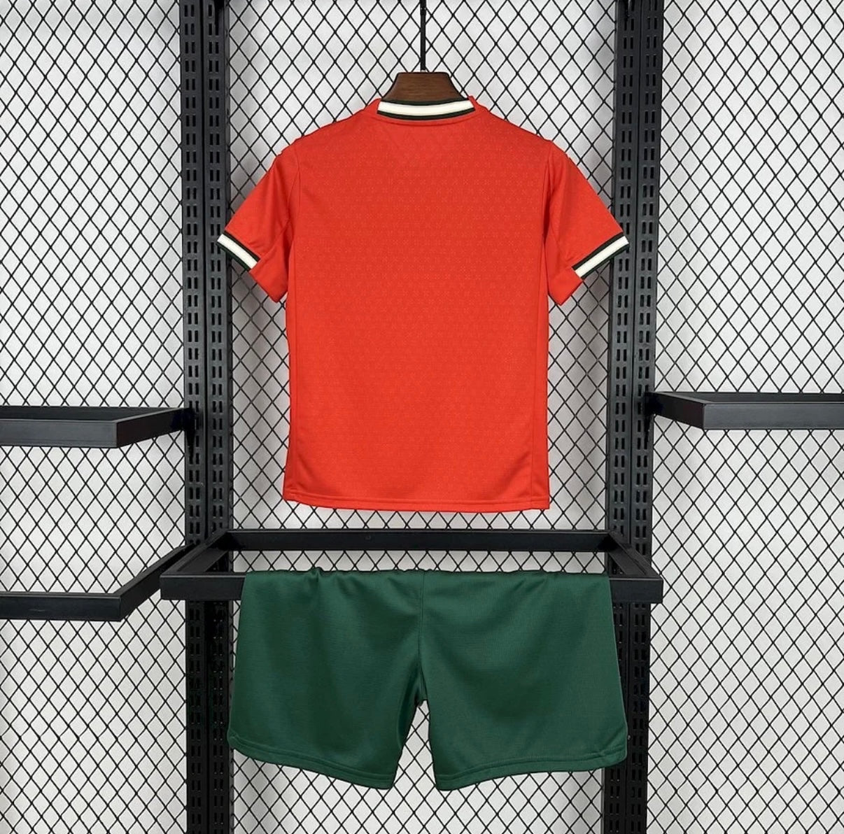 Leazofoot Portugal 2025 kids home kit featuring a red jersey with striped collar and green athletic shorts.