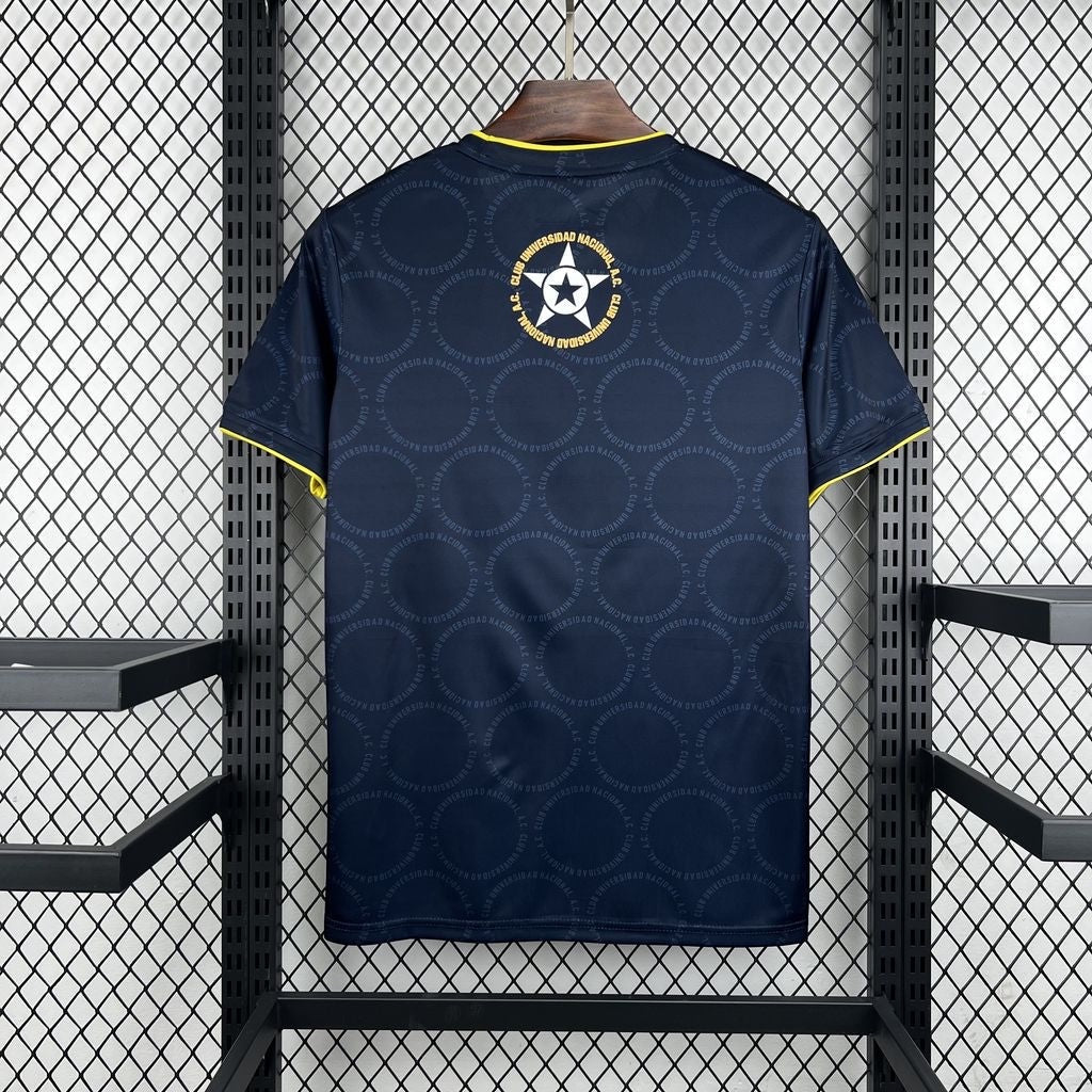 Leazofoot Pumas 26/27 away soccer jersey in navy blue with yellow trim and repeating circular club logo pattern.
