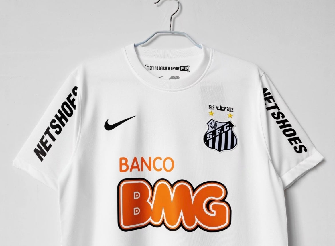 Leazofoot white Santos 2012-13 away soccer jersey with sponsor logos and club crest on a hanger.