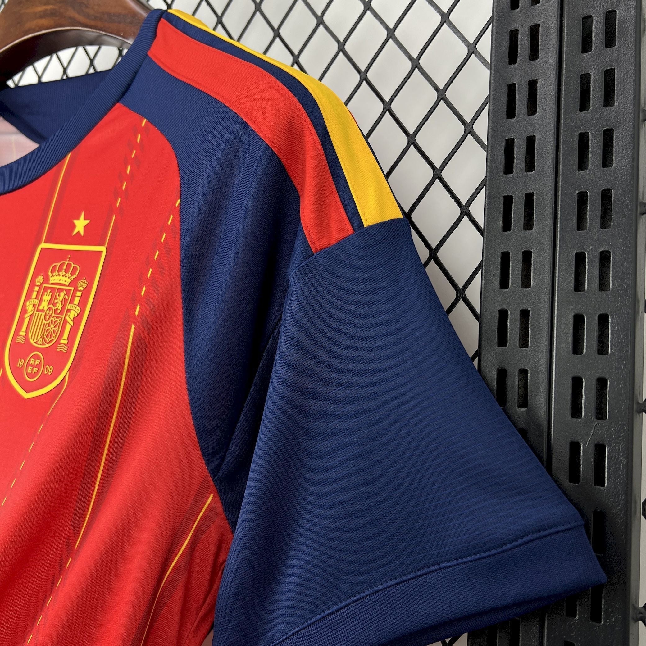 Leazofoot Spain 2026 home soccer jersey. Red with yellow accents and navy blue sleeves. Features the Spain crest.