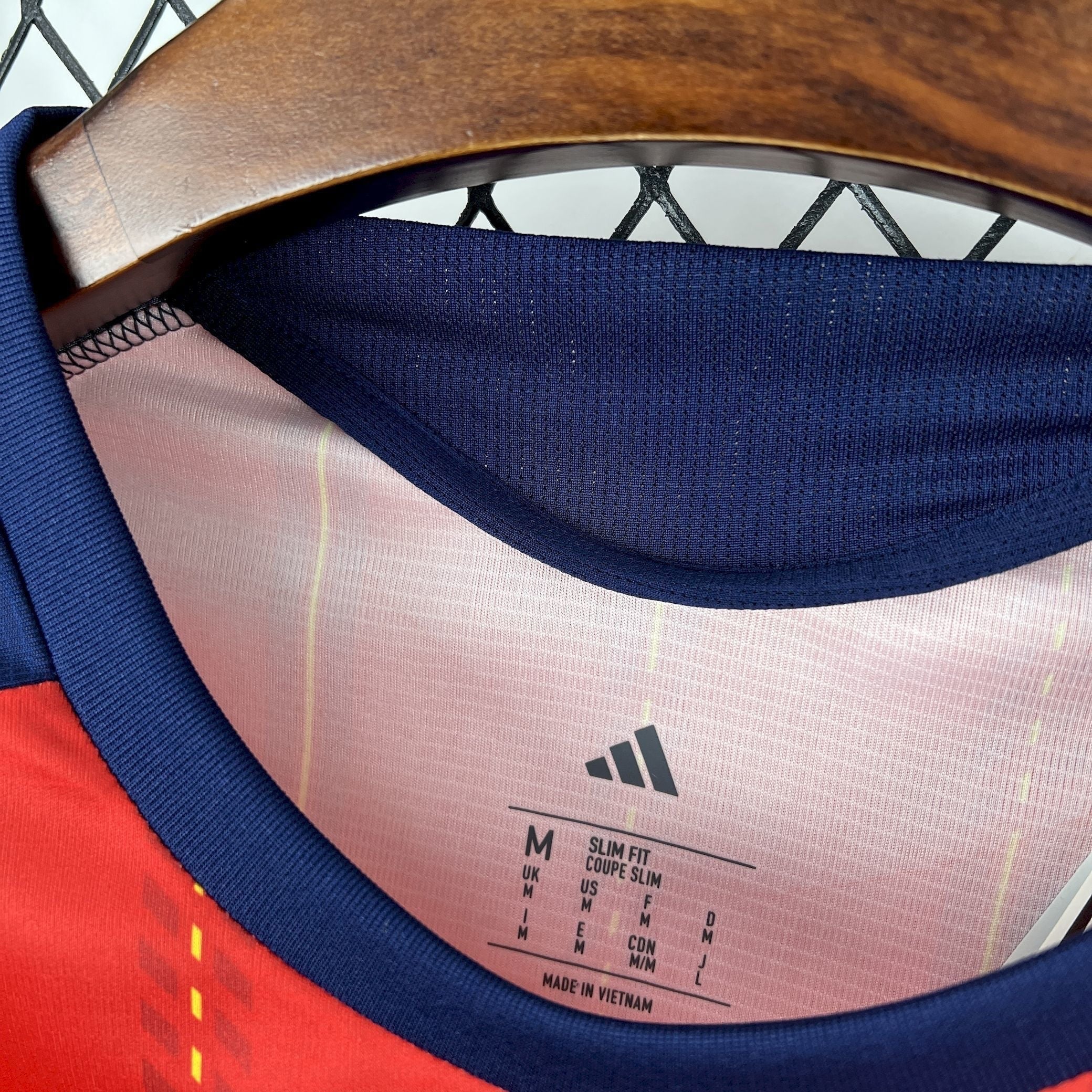 Leazofoot Spain 2026 home jersey with red and yellow stripes and navy blue collar and trim.