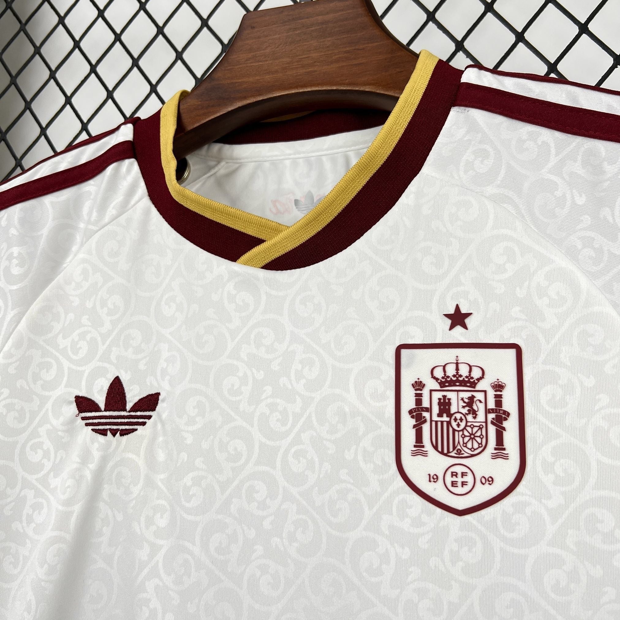 Leazofoot Spain kids' outdoor football kit 2026. White jersey with burgundy and gold trim, featuring the Spain crest and Adidas logo.
