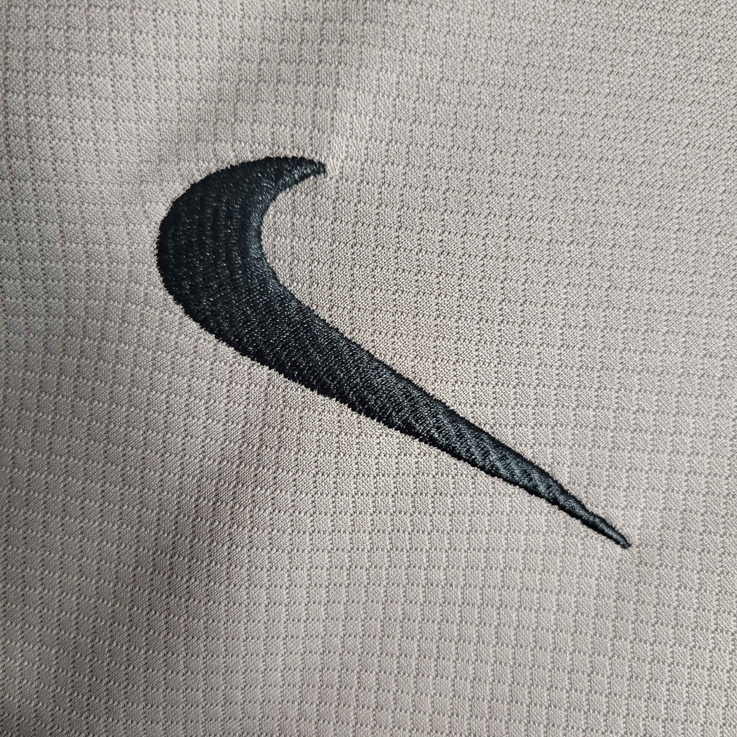 Leazofoot Tottenham 23/24 third jersey with black Nike swoosh logo on a light grey textured fabric.