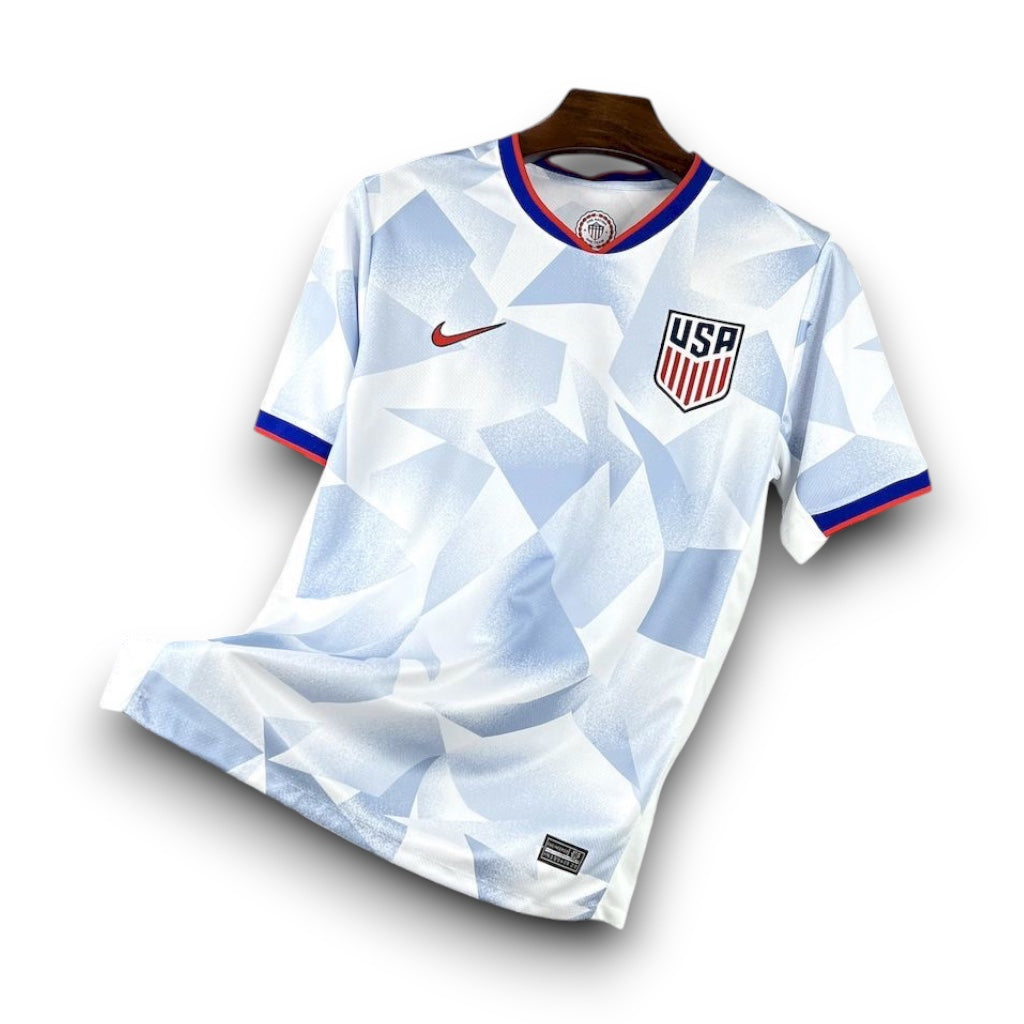 Leazofoot 2025 USA home soccer jersey in white with a blue geometric pattern, red accents, and team crest.