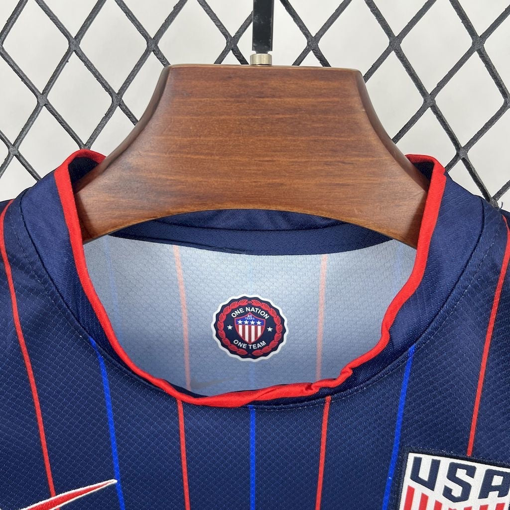 Leazofoot 2025 USA kids away soccer jersey in navy blue with red and blue vertical stripes and team crest.