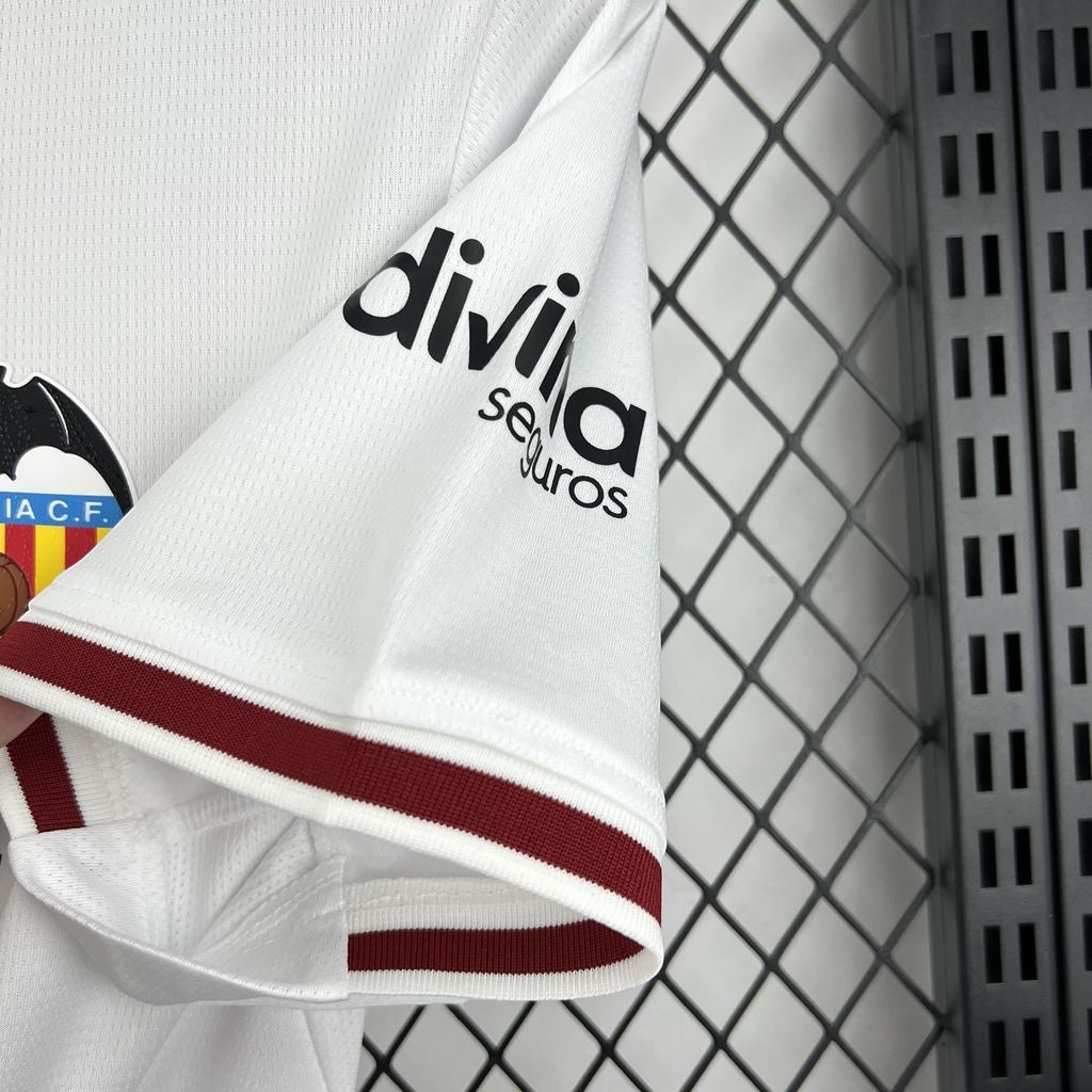 Leazofoot Valencia CF 26/27 home jersey sleeve detail featuring white fabric, maroon trim, and Divina Seguros logo.