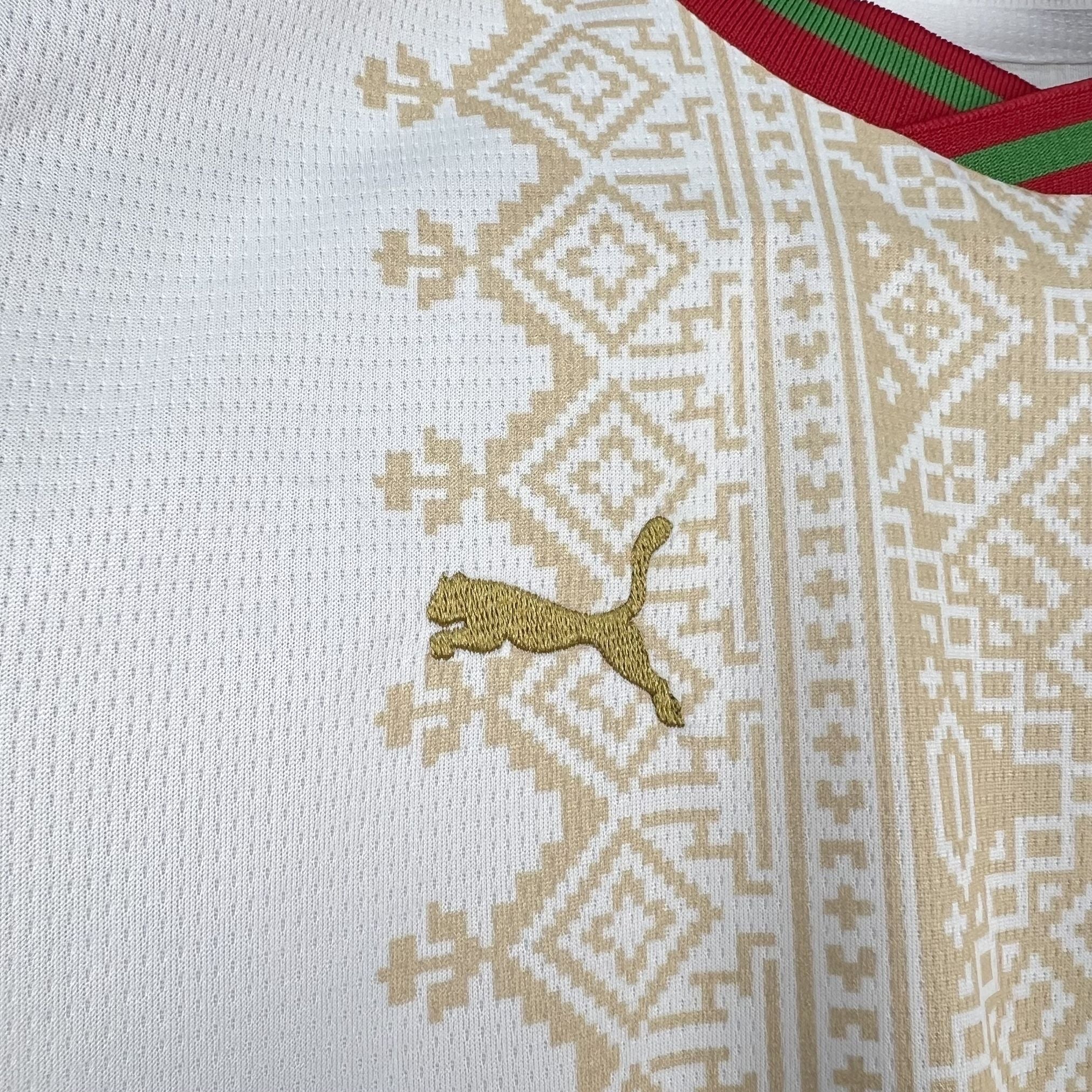 Leazofoot white and gold patterned soccer jersey with red and green trim.