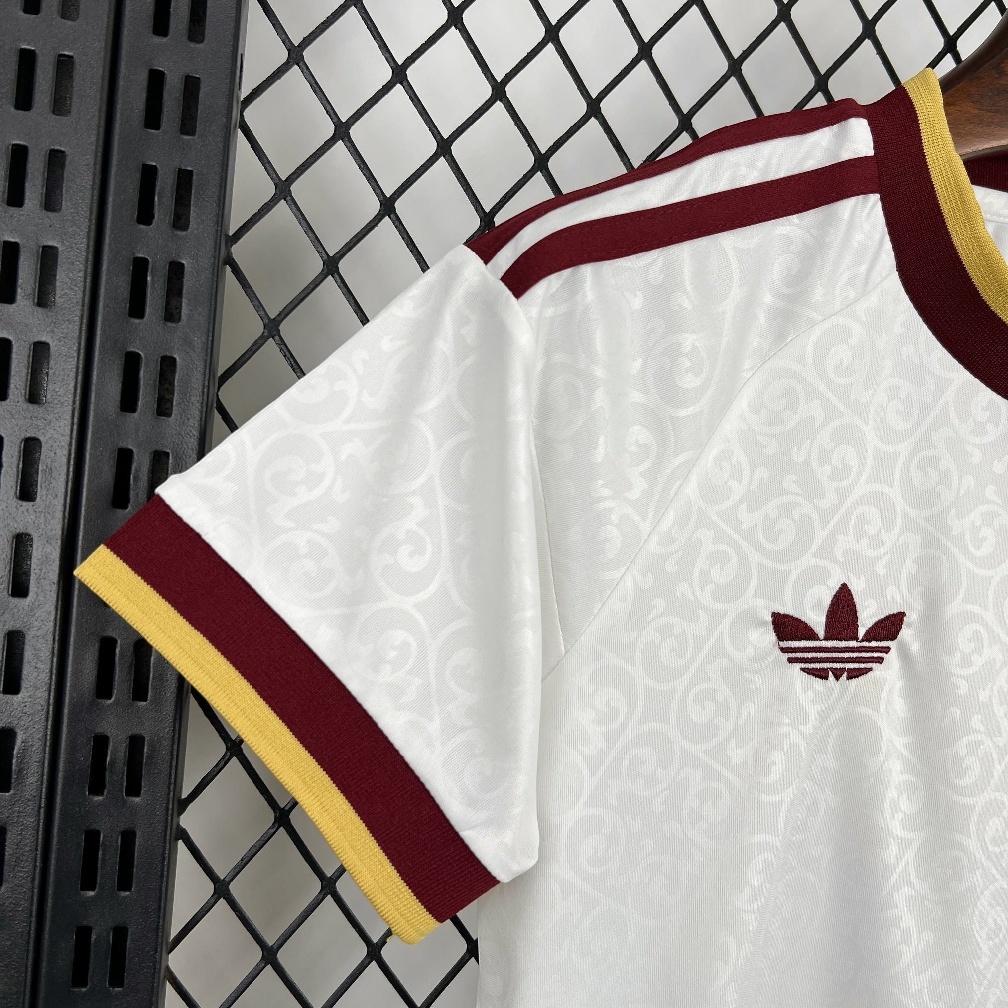 Leazofoot white short-sleeve t-shirt with maroon and yellow trim, featuring a subtle damask pattern and maroon Adidas logo.