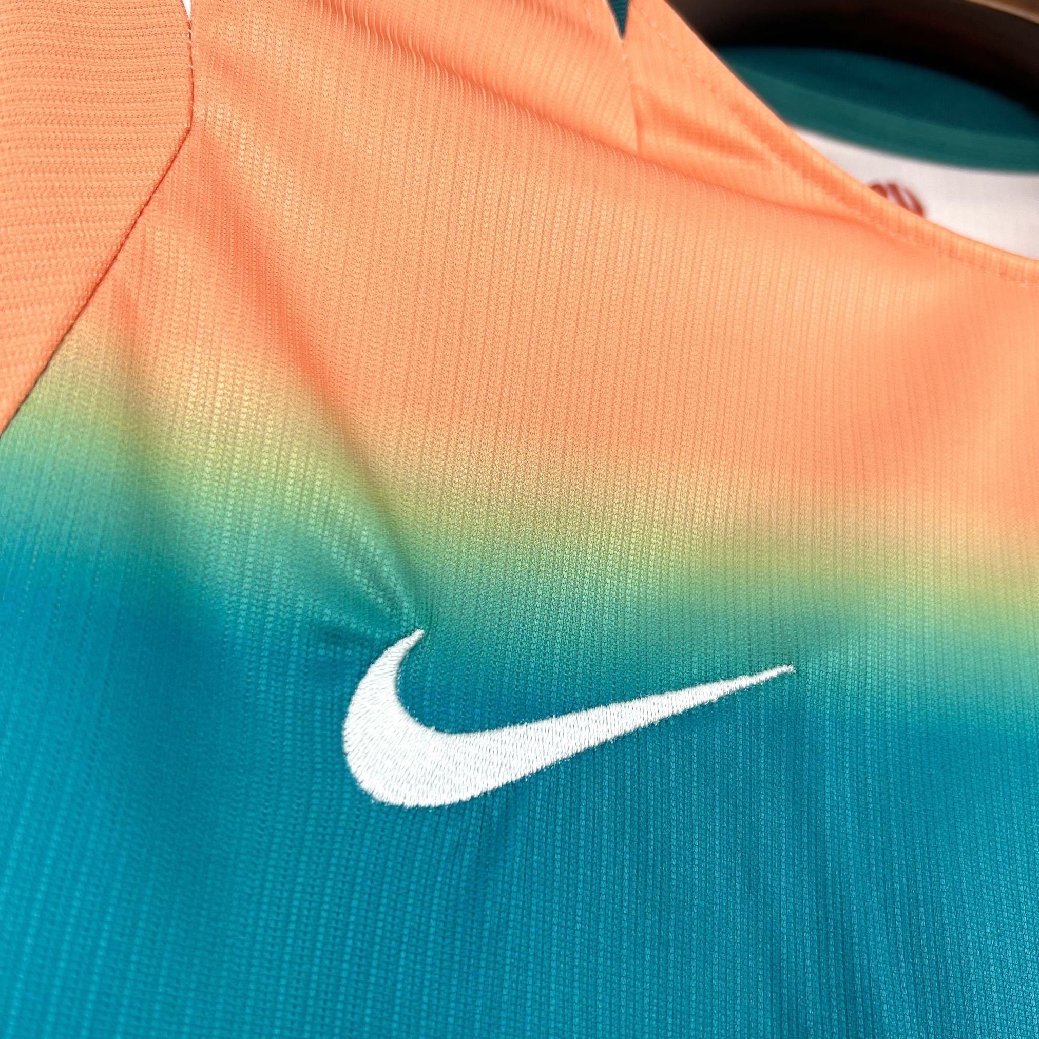 Leazofoot AUSTRALIE - MAILLOT EXTÉRIEUR 2026 jersey with a white Nike swoosh logo and a gradient of orange, yellow, and teal.
