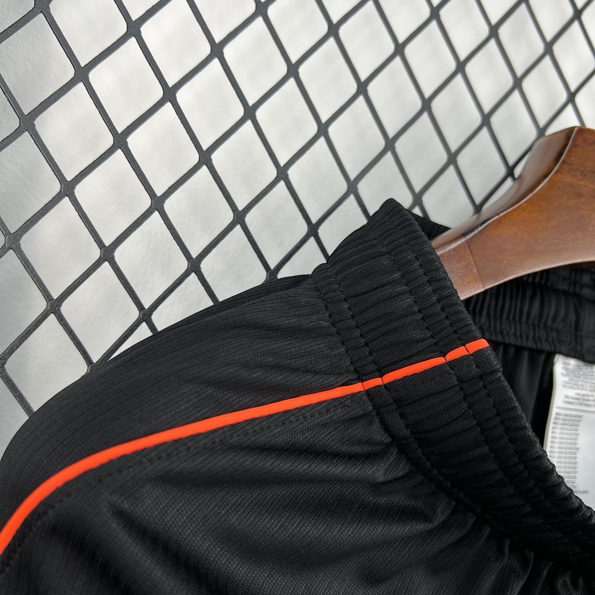 Leazofoot black athletic shorts with orange piping detail on elastic waistband
