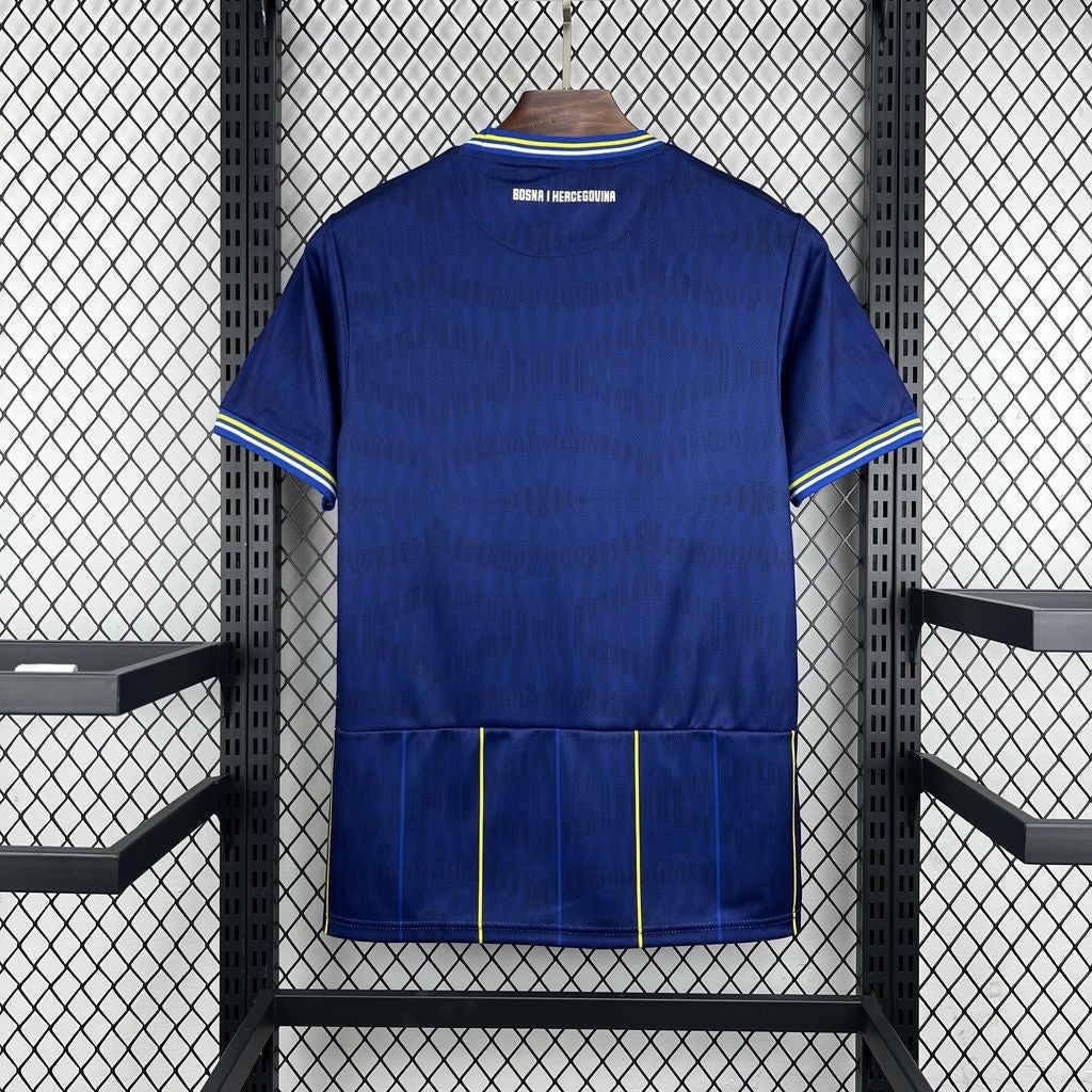 Leazofoot BOSNIE - MAILLOT DOMICILE 2026 blue soccer jersey with yellow and white trim on collar and sleeves.
