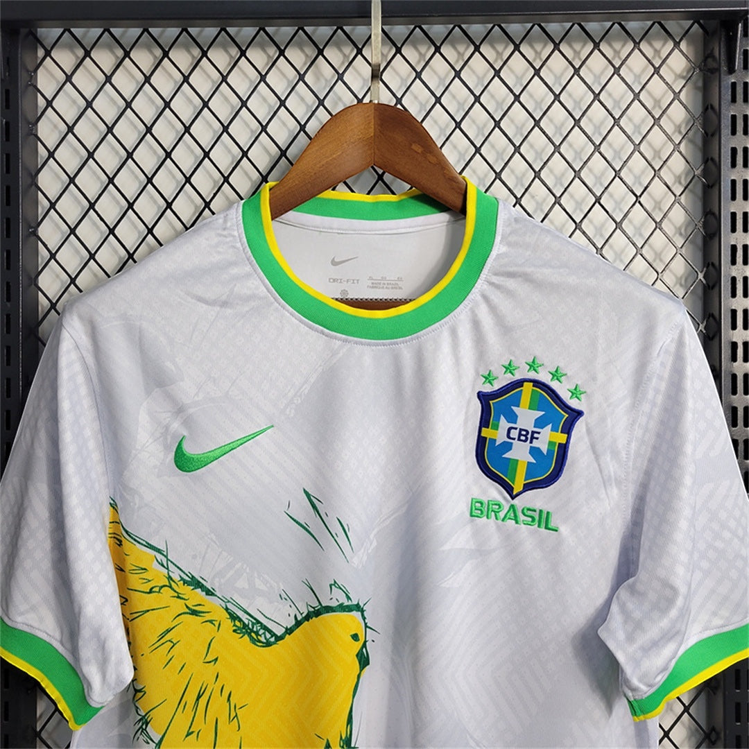 Leazofoot white Brazil 2024 concept soccer jersey with yellow bird graphic, green trim, and CBF crest on hanger
