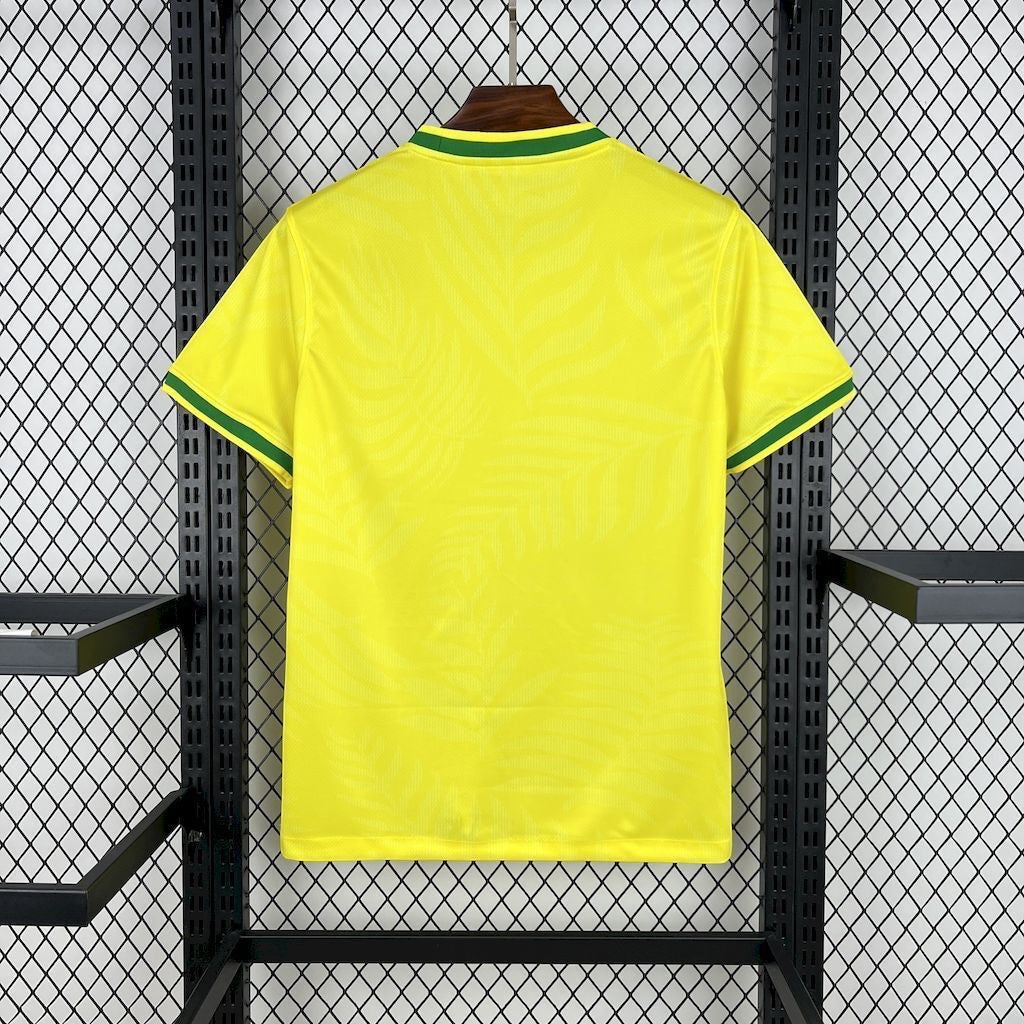 Leazofoot Brazil 23/24 yellow football jersey with green trim and subtle leaf pattern texture on a display rack.
