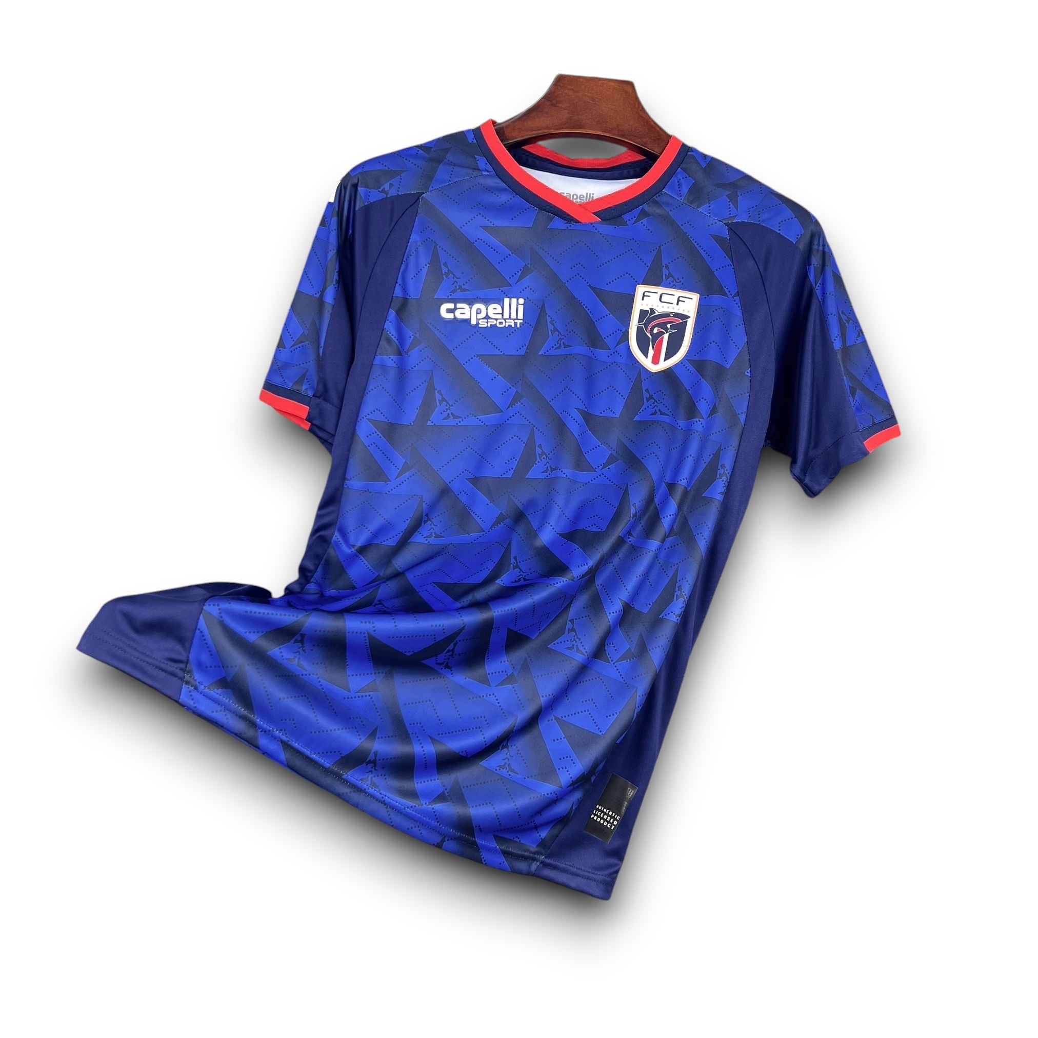 Leazofoot CAP-VERT 2026 home football jersey in blue with a geometric star pattern and red trim.