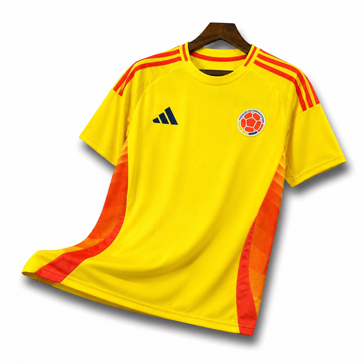 Leazofoot Colombia 2024 home soccer jersey in yellow with red side panels and shoulder stripes on a hanger.
