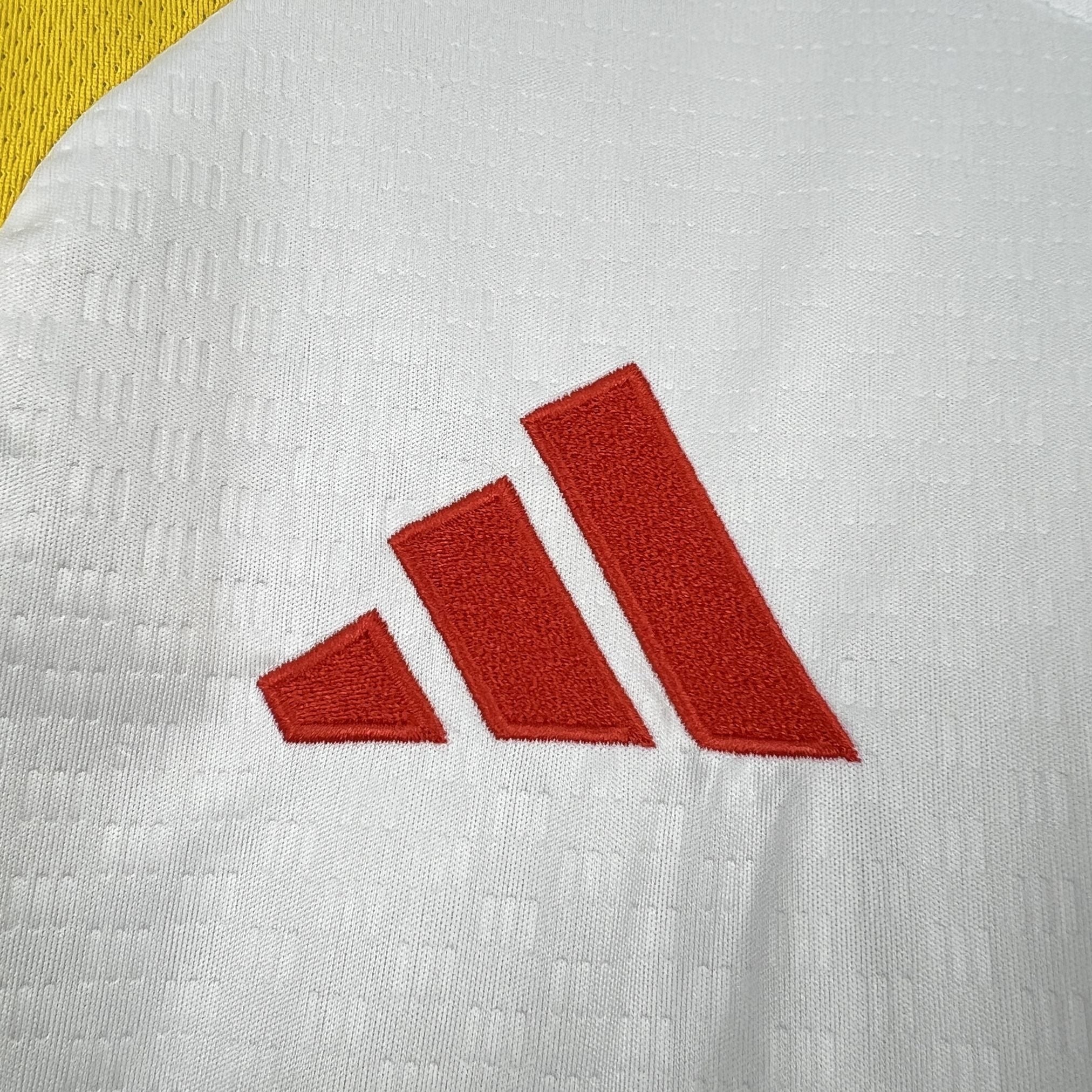 Leazofoot COLOMBIE 2026 pre-match jersey with red Adidas logo on white textured fabric and yellow trim.