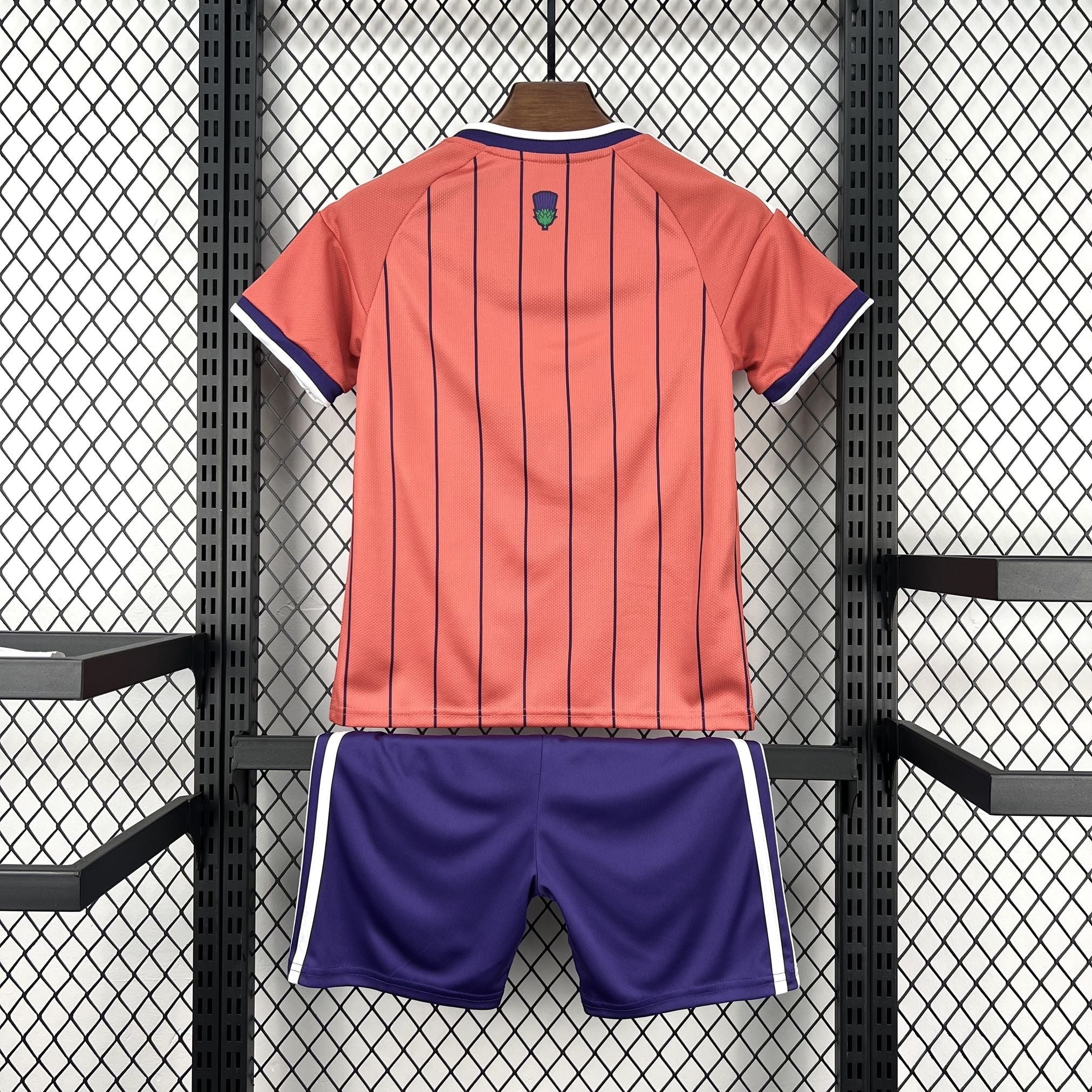 Leazofoot ÉCOSSE children's soccer kit: coral jersey with navy pinstripes and purple shorts with white trim.