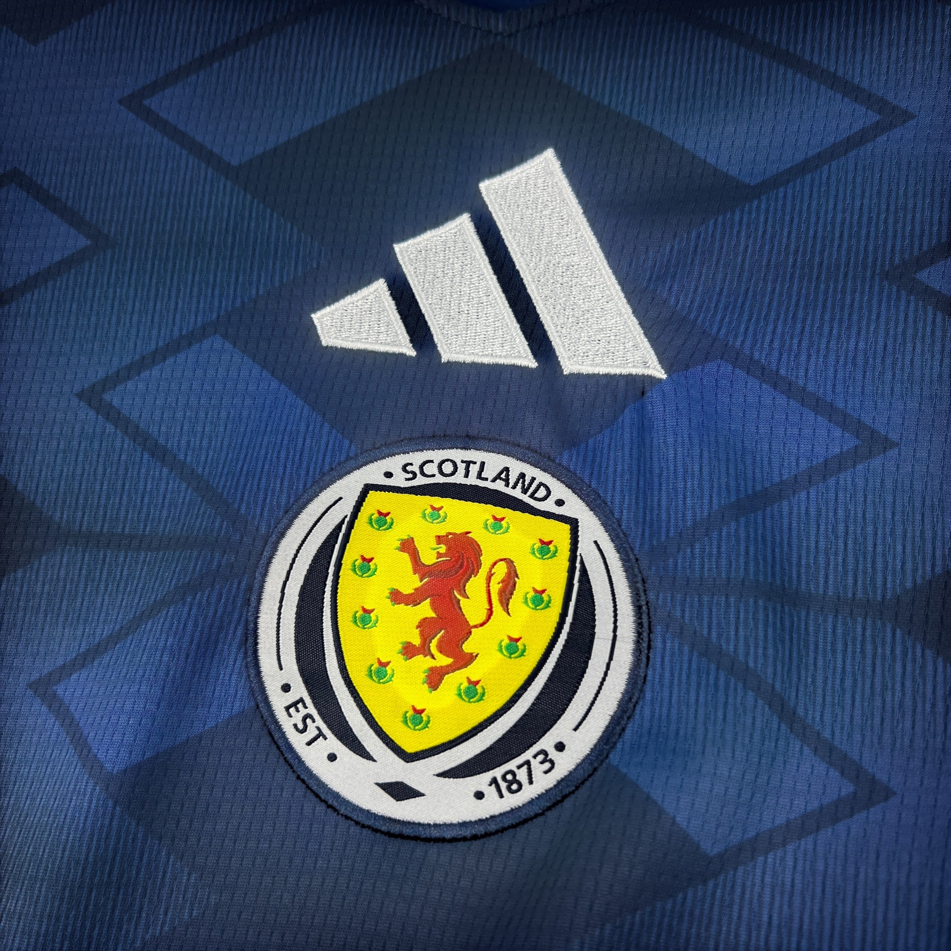 Leazofoot ÉCOSSE MAILLOT DOMICILE 2026 home jersey with Scotland crest and Adidas logo. Navy blue with geometric pattern.