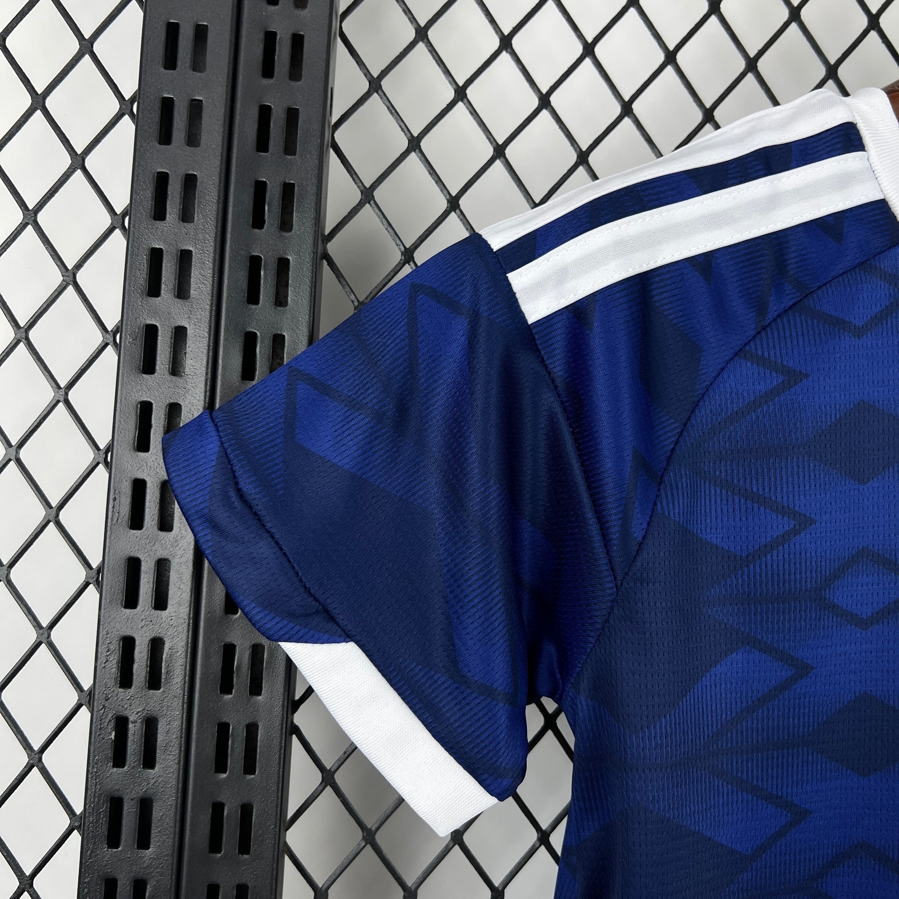 Leazofoot ÉCOSSE - ENSEMBLE ENFANT DOMICILE 2026 kids' home jersey with blue geometric pattern and white stripes on sleeves.