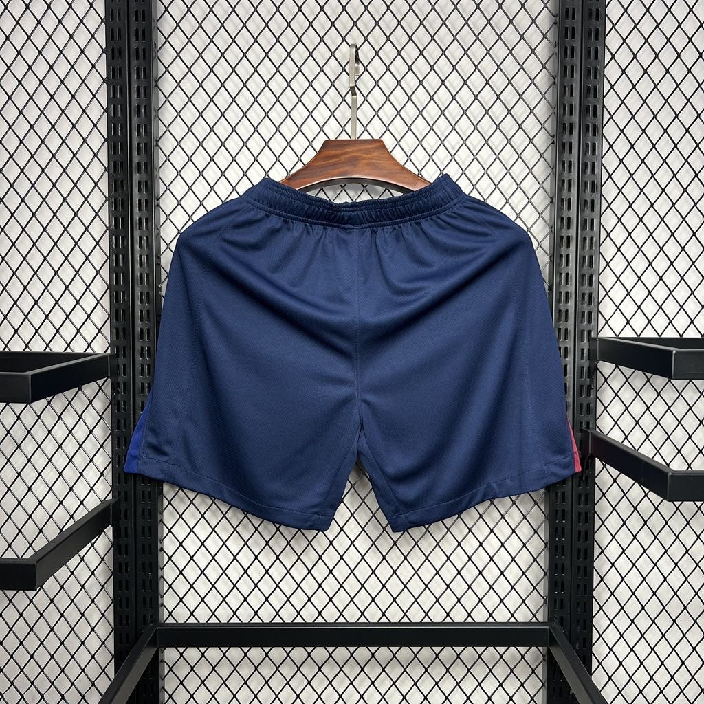 Leazofoot FC Barcelona 24/25 home football shorts in navy blue with elastic waistband hanging on a wooden hanger