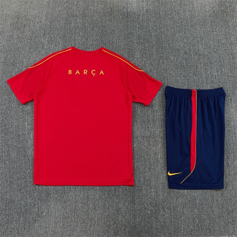 Leazofoot FC Barcelona 26/27 training kit featuring a red short-sleeve shirt with yellow text and navy blue shorts.